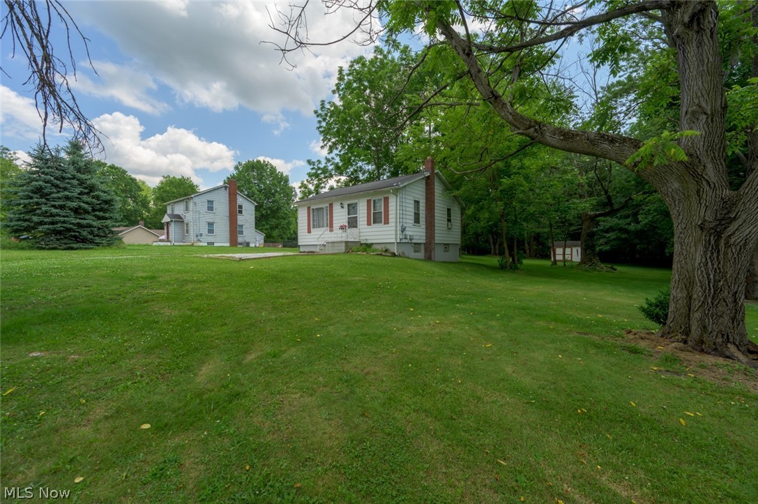 Affordable Charm with Acreage in the Tallmadge School Distric! Unbeatable value meets expansive outdoor living in this move-in-ready gem! Priced under $150K, this charming home offers a rare blend of budget-friendly living situated on nearly an acre of park-like surroundings.  Whether you are looking for financial freedom, low utilities, or room to breathe and enjoy the outdoors, this property delivers it all!  Just minutes from the historic Tallmadge Circle, Route 76 and all the parks and recreational facilities that Tallmadge has to offer. The main level of this home offers comfort & character - step inside to a bright, welcoming living area featuring beautiful original hardwood flooring. In addition, the main level hosts two comfortable bedrooms, and a full bathroom—perfect for single-level daily living. The uniquely designed lower level maximizes every square foot, offering a spacious kitchen fully equipped with a stove and refrigerator that stay with the home, a flexible third bedroom that can be utilized as a private guest room, hobby space, or quiet home office. The lower level also consists of a dedicated laundry room, complete with a washer and dryer (hookup) for your convenience, a large utility and storage area that keeps your living spaces clutter-free. Outside your private oasis is the true crowning jewel of this property. The spectacular lot offers serenity, a large concrete patio sits ready for summer BBQs, outdoor dining, and relaxing.  A spacious outbuilding easily secures your lawnmower, tools, and outdoor gear.   Enjoy the peace of a massive lot combined with the worry-free reliability of city water and sewer. Don't Miss Out! Opportunities to own this much land in Tallmadge at this price point are incredibly rare. Come see the value for yourself at our Open House this Sunday, July 5th, from 11:00 AM to 1:00 PM!