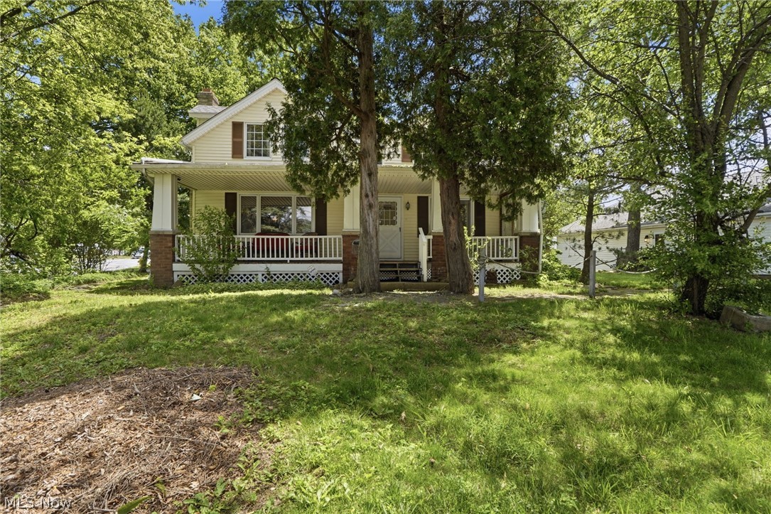 Standing tall atop State Rd hill, this home has the convenience of side street access, the capability of one-floor living, an incredibly unique garage and a history dating back to the bedrock of Parma! (Plus - much more!) Said to be one of the first homes on this section of State Rd, the address is carved into a stone which once held anchor for the tethering of horses before Parma was graced with paved roads and automobiles. Mature trees and a generous set-back provide a private feel while maximizing the enjoyment of a classic covered front porch! Inside is surprisingly open with a great flow. Rich, hand scraped Bamboo flooring spans the living room, dining room and the first floor flex room which is perfect as a bedroom, an office, or as a family room. The living room features beamed ceilings, crown molding and a beautiful full wall, brick-front fireplace with gas starter - currently utilizing gas logs and could be wood burning if so desired. The kitchen is huge with its own eating area, a breakfast bar and quality cabinetry that amplifies function, character and timeless style. At the back of the home is a family room, a laundry room and a large full bath - providing everything one could need on the main level. An additional full bathroom and three more bedrooms are located upstairs along with plenty of storage. The basement provides additional storage - as does the incredibly unique garage! Equipped with a workshop, half bath and a storage loft! This is a handy-person’s dream! Even the driveway is extra thick and can handle heavy trucks, etc. Another touch of quality is the Pella windows throughout the home. Extensive plumbing and electrical upgrades have been made and for peace of mind, the roof was replaced in 2010, HVAC 2009, water tank 2017. You simply can’t find a better offering at this price. If you’ve been shopping, you know you’re running out of time to have a chance at this one - Set your appointment today!