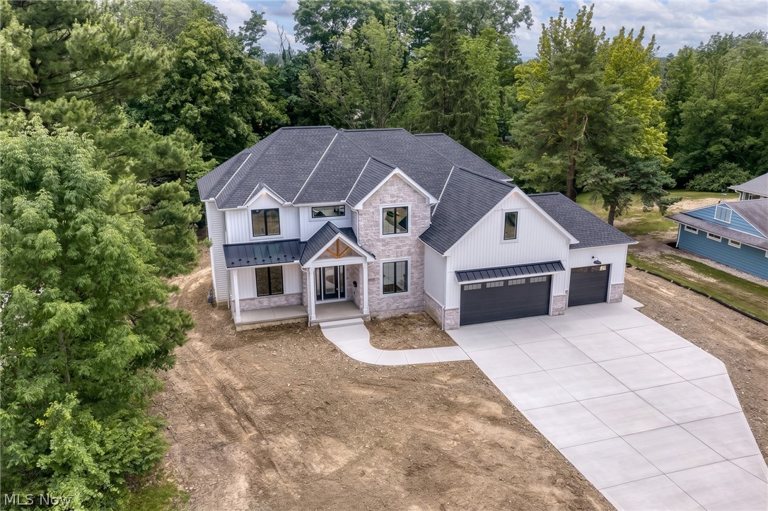 Dommus Construction delivers a true masterpiece in every sense of the word. Experience the Dommus difference at this stunning, custom-built luxury estate, where architectural brilliance meets an unparalleled natural setting. Nestled in a prime, highly sought-after location in Beachwood, this brand-new construction home sits beautifully on a 1-acre, deeply wooded parcel, offering an exquisite blend of private sanctuary & sophisticated living. A master piece of luxury & nature, this new build is the height of custom craftsmanship. This 4,000 sq ft, 5-bedroom, 5-bathroom residence showcases elite craftsmanship & bespoke design elements. From the moment you step inside, the attention to detail is undeniable. Featuring architectural artistry, show-stopping features, & curated finishes. Dramatic coffered ceilings, striking exposed beams, & custom built-ins add timeless character. A magnificent, real wood floating staircase serves as a structural work of art, anchoring the home’s open-concept flow. Each of the 5 bathrooms is a spa-like retreat, boasting stunning, intricate tile work & premium fixtures. An entertainer’s culinary dream awaits. The heart of the home is a massive chef’s kitchen, meticulously designed for high-end entertaining with prestigious JennAir Professional Line appliances, massive center island & walk-in pantry. Indoor-outdoor living designed to embrace its magnificent 1-acre wooded backdrop & private forest. The welcoming front porch offers classic curb appeal. The elevated rear covered porch is the ultimate outdoor space, perfect for al fresco dining overlooking the serene, mature trees. The sun-drenched lower level features massive garden windows that flood the space with natural light. Opt to finish this expansive basement to create the ultimate custom recreation zone, gym, or media room. This is more than just a home; it is an elevated lifestyle experience crafted by one of the area's premier builders. Experience the Dommus Difference firsthand.