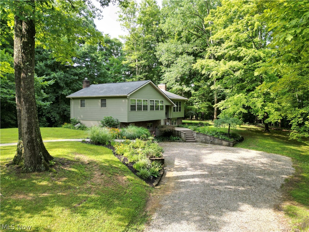 Nestled among beautiful mature trees on 5 secluded acres, this well-maintained home offers the peaceful country setting you've been searching for! Owned and lovingly cared for by the same family for over 30 years, this property is surrounded by picturesque woods that have never been timbered, creating exceptional privacy and a truly serene setting. Inside, you'll find 3 bedrooms, 2.5 baths, an updated kitchen, spacious dining area with access to the deck, and a finished walkout lower level featuring a large family room with a stunning wood-burning fireplace insert and hearthstone, perfect for gathering with family and friends. The spacious primary suite includes an updated private bath, while recent interior paint and newer carpet add to the home's move-in ready appeal. Outside, enjoy the expansive deck, patio, beautifully landscaped yard, oversized 2-car detached garage, and additional lean-to for extra storage. The garage is insulated, heated, and equipped with 100-amp/220-volt electrical service, making it an excellent space for hobbies, projects, a workshop, or recreational use. Additional improvements include newer windows, siding, and a new roof in 2021. If you've been dreaming of a private retreat with abundant wildlife, towering trees, beautiful landscaping and a setting that feels miles away from it all while remaining conveniently located, this is one you won't want to miss!