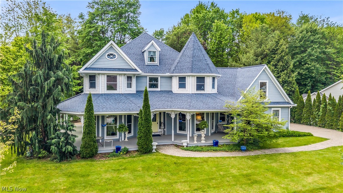 Tucked away on a quiet cul-de-sac, this extraordinary Victorian-inspired home blends timeless craftsmanship with modern comfort on a beautifully landscaped 3/4-acre wooded lot. The desirable lot-and-a-half setting provides exceptional privacy and green space, ensuring no homes can be built directly between you and the neighboring properties. From the cobblestone driveway and inviting front porch to the private backyard, every detail has been thoughtfully designed to create a one-of-a-kind retreat. Inside, you’ll find incredible custom woodworking, intricate built-ins, and stunning wood flooring throughout. The impressive foyer opens to a spacious, light-filled floor plan featuring a formal dining room, elegant front sitting room, and a warm living area anchored by a custom gas fireplace. The eat-in kitchen is both functional and beautiful, offering an oversized pantry, abundant cabinetry, and seamless flow for entertaining. Upstairs, the luxurious owner’s suite feels like a private sanctuary with dual sinks, soaking tub, and massive walk-in closet. Two bedrooms share a Jack-and-Jill walk-in closet and full bath, while an additional oversized bonus room offers flexibility as a fourth bedroom, office, or rec space. A finished basement with a family room and half bath adds even more room to spread out. Surrounded by nature near Cuyahoga Valley National Park and Blossom Music Center, this exceptional home offers easy access to both Akron and Cleveland while feeling worlds away.