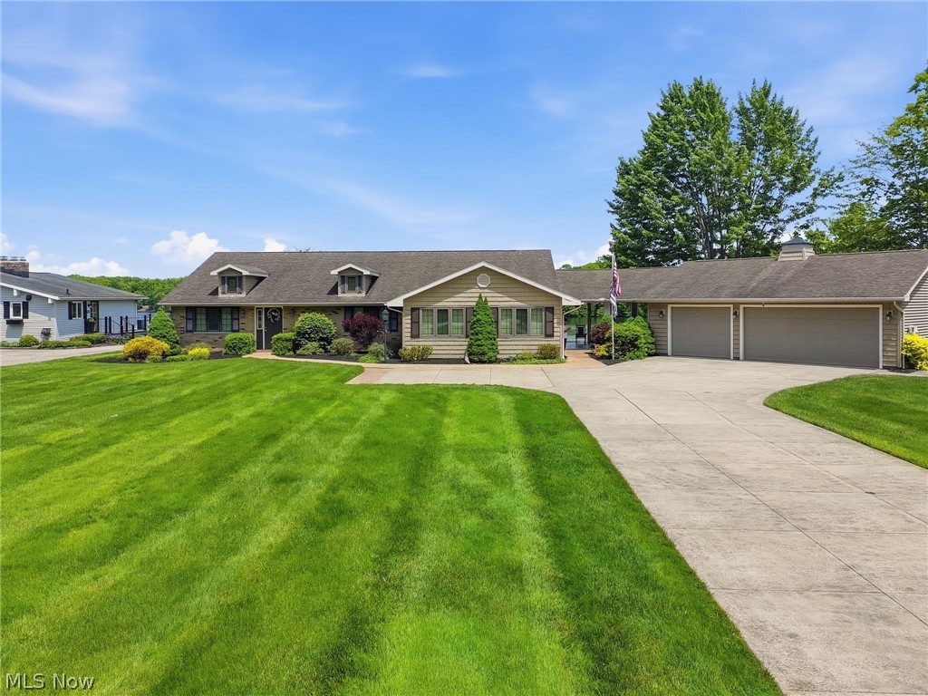 Welcome to lake life at its finest in the heart of Roaming Shores! Situated on two lakefront lots along one of the widest parts of the lake, this meticulously maintained brick ranch offers exceptional water views, extensive outdoor entertaining space, and direct access to all the community amenities. Enjoy panoramic lake views, including front-row seats to the annual fireworks display, while being just a short distance to the clubhouse, pool, beach, and concession area. Outdoor features include over 2,300 sq. ft. of stamped and textured concrete patio and deck areas, a decorative waterfall with flowing stream and bridges, two fire pit gathering areas, a paved golf cart path to the water, floating dock, double seawall with concrete boardwalk, boat garage, and a spacious breezeway providing additional covered outdoor living space. A designated hot tub pad and gas outlet for grilling add to the property's entertaining appeal.

Inside, the home offers comfortable single-floor living with a seamless flow between indoor and outdoor spaces. Improvements include updated furnace with humidifier and air cleaner, central air conditioning, electrical and plumbing upgrades. BONUS:  Titan 9000 ES Generator! The oversized paved driveway leads to the attached 3-car garage, additional storage building for boat storage, and ample parking space. Most furnishings will remain, making this an outstanding opportunity to begin enjoying lakefront living right away. A rare combination of location, views, outdoor amenities, and thoughtful updates in one of Roaming Shores most desirable settings.