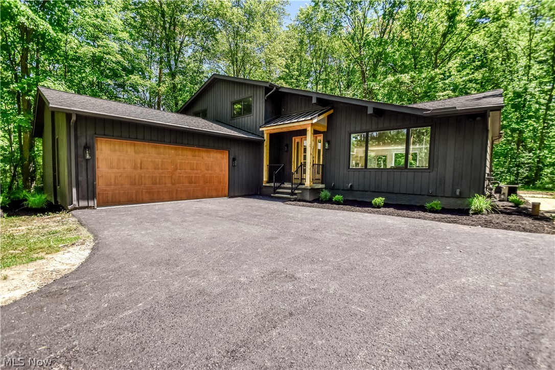 Welcome to this extraordinary, fully renovated luxury residence nestled on a private wooded lot in highly sought-after Aurora and the award-winning Kenston School District. Completely transformed from top to bottom, inside and out, this stunning 4-bedroom, 3-full-bath home offers the perfect blend of modern design, premium craftsmanship, and everyday functionality. The impressive exterior showcases striking contemporary curb appeal with custom wood accents, updated landscaping, and an attached 2-car garage. Inside, the open-concept floor plan is flooded with natural light and features wide-plank flooring, soaring spaces, designer lighting, and high-end finishes throughout. At the heart of the home is a show-stopping chef's kitchen featuring custom cabinetry, quartz countertops, an oversized waterfall island, stainless steel appliances, beverage cooler, and abundant storage. The spacious living and entertaining areas flow seamlessly to the outdoor deck and wooded backyard, creating the perfect setting for indoor-outdoor living. The luxurious primary suite offers a spa-inspired retreat complete with a beautifully appointed bath and custom walk-in closet. Every bathroom has been thoughtfully redesigned with upscale fixtures, elegant tilework, and modern finishes. An expansive lower-level living area provides additional space for entertaining, recreation, or relaxing. Move-in ready and meticulously renovated, this exceptional property offers luxury living in one of Northeast Ohio's most desirable communities. A rare opportunity to own a like-new home with designer finishes, privacy, and convenience all in one remarkable package.