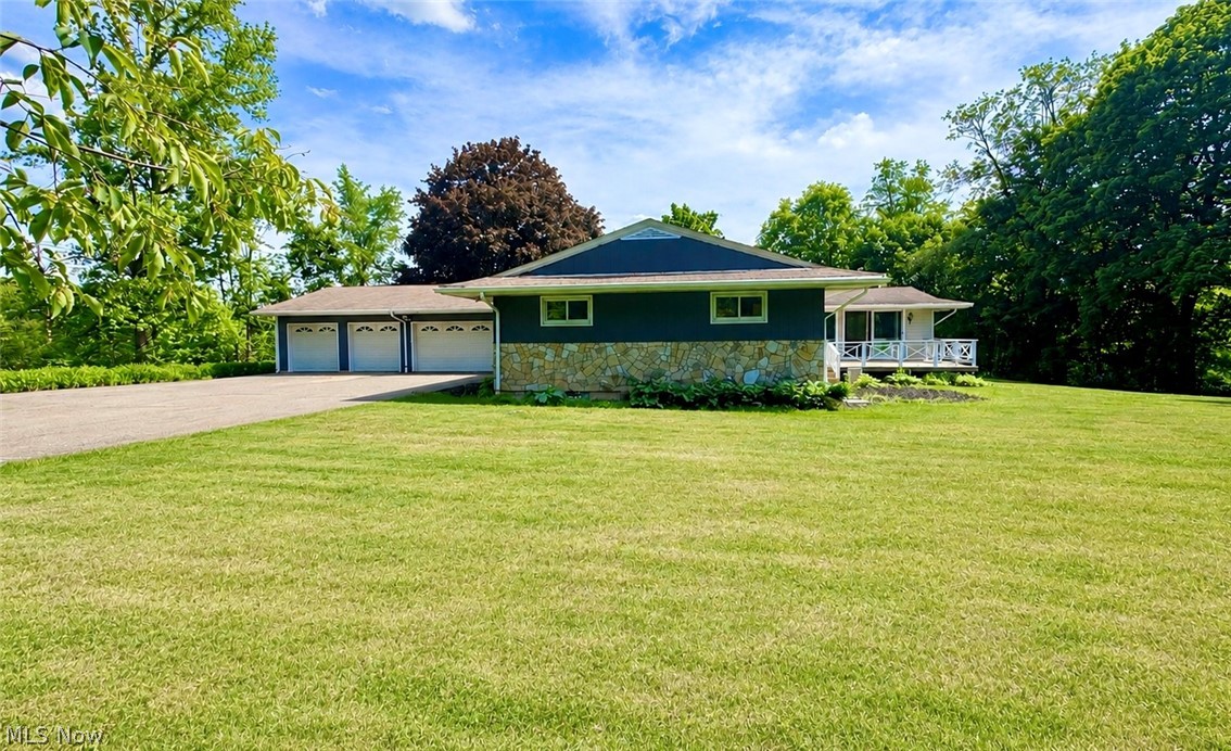 Stunning and expansive- A fully remodeled 3-bedroom, 2 full bath ranch home set on a private corner lot of nearly 1.5 acres. This exceptional property has been thoughtfully redesigned with creative refinishes throughout, including a beautifully upgraded kitchen featuring new stainless KitchenAide appliances, tumbled marble backsplash and butcher block counter tops. Two all new bathrooms complete with LVT flooring and tub/shower combo. The exterior has been freshly painted and complemented by a blacktopped driveway, enhancing both curb appeal and functionality! Designed for both comfort and entertaining, the Great Room where windows abound, allowing for natural sunlight, views and showcases a custom bar area and indoor grill creating a true gathering space. The home offers two fireplaces—one wood-burning and one electric, with the option to convert back to wood-burning if desired. 
Additional amenities include central air, energy-efficient double-pane windows, and a newly constructed deck overlooking the serene, private grounds. The full unfinished basement provides a half bath, laundry area with chute access, and unlimited potential for additional living space.
An oversized 4-car garage offers ample room for the vehicle enthusiast, storage, or a workshop. A rare offering that seamlessly blends privacy, modern upgrades and exceptional space both inside and out. Located in award winning James A Garfield school district and an easy commute to Cleveland, Akron or Youngstown!