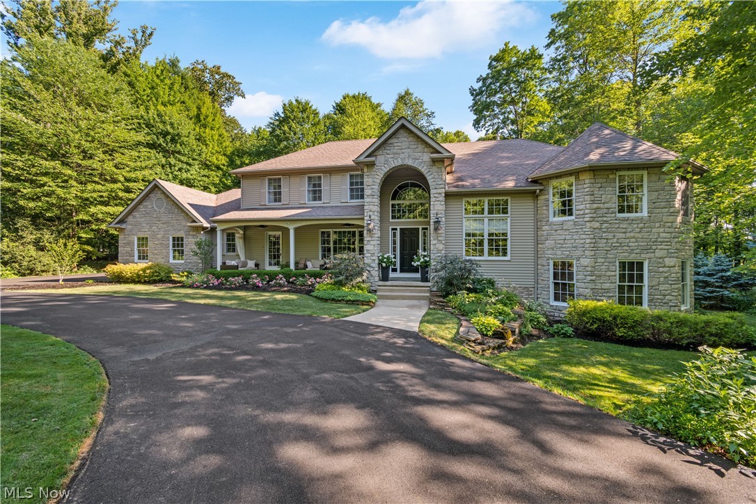 South-facing, one of a kind split-level home w elevator, enveloped by exquisite landscaping & 2.5 private wooded acres. Repaved circular drive leads to inviting 6’ deep front porch. Dramatic 2-story foyer w hardwood floors, extensive trim, & switchback stairs is flanked by a formal dining room w wainscoting, & a study w glass-paned French doors & volume ceiling. Great room boasts 11’ ceilings, large windows & striking floor-to-ceiling stone fireplace. Spacious renovated kitchen has wood floors, granite countertops, coffee bar, center island w seating, subway tile backsplash, wall oven/microwave, pantry, & dinette area w slider access to back patio. Down the hall is a laundry room, half bath, porch access. Stairs from foyer or great room lead down to half level w bayed rec room, 2nd office, & cozy pub room w cherry L-shaped wet bar–each room w walkout access! Heading upstairs to the first landing is the vaulted master retreat w bay window, linen closet & en-suite bath offering walk-in c