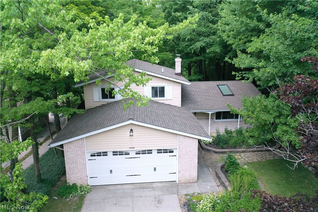 Waiting for your move in condition home?  Wait no longer, for this charming split level home has newer carpet, flooring, paint, and windows.  Vaulted ceilings in the Living Room, with a skylight, Dining Room and Kitchen creates an openness most desired. The kitchen has ample counter and cabinet space, with a skylight to allow natural sunlight to brighten your day.  The Family Room has a full brick wall gas fireplace, bead board paneling, and a window wall for added natural sunlight, which opens to the deck.  Laundry/Mud Room is spacious with a half bath and is on the main level for easy access.  Fenced in private rear yard with lush landscaping.  Stone walk to the front yard.  And with a private sewer, no worries about a septic system.  Great location.  Close to the center of Chesterland for shopping and dining.  Schedule your appointment now.