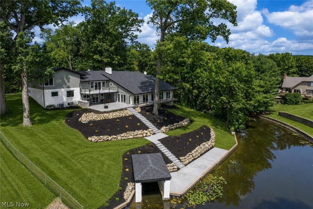 Exceptional lakefront living on Rex Lake! This completely reimagined contemporary split-level offers 3 bedrooms, 3.5 baths, over 4,500 square feet, a 4-car attached garage, and incredible indoor-outdoor spaces designed to take full advantage of the water views. A wide driveway leads to the striking covered front entry with wood pillars, opening into a spacious foyer with a large drop zone, accent wall, generous closet, nearby office/flex space, first-floor laundry, and half bath.

The heart of the home is the luxurious eat-in kitchen featuring custom full-extension, soft-close dovetail cabinetry, quartz countertops, Frigidaire Gallery stainless steel appliances, center island, breakfast bar, black tile backsplash, floating shelves, and a dining area overlooking the lake. A few steps up, the formal living room showcases vaulted ceilings, a wood-burning fireplace, and sliders to a private balcony with new railing and peaceful water views.

Upstairs are three bedrooms and a beautifully remodeled full bath, including the primary suite with corner windows overlooking the backyard and lake, a walk-in closet, and private bath with dual-sink vanity and 5x5 walk-in shower. Down off the kitchen, the family room adds a wet bar with seating, quartz counters, wood-burning fireplace, and expanded living space on the covered patio.

The additional party/rec room is truly impressive, offering 2-story-cathedral ceilings, expansive sliders with built-in blinds, a full bath ideal after lake days, storage rooms, spiral stairs lead to the generous loft space with garage access. Outside, enjoy stamped concrete patios, a covered outdoor kitchen with built-in gas grill and beverage fridge, new deck, fresh landscaping, new concrete steps to the lake, new seawall, boathouse updates, and covered boat slip. Major 2026 updates include roof, siding, gutters, soffits, windows, garage doors, interior/exterior doors, flooring, lighting, fixtures, and recessed lighting.