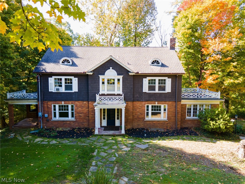 Here is your chance to own a stunning, and very unique home in Chagrin Falls! When you pull up to this spectacular 3,900 square foot home, you will
see it is situated on 3.4 acres, and it's on a very desirable corner lot. Even though you are only about a mile from town, you are in a secluded and private area. The tree-lined driveway leads to a magnificent five-bedroom, four-and-a-half-bathroom home.  Entering the front door, you will be greeted by the amazing two-story foyer and grand double staircase. On the first floor, you will find a formal dining room with built-in storage. To the right of the grand staircase is a massive living room with an elegant brick fireplace, and an entrance to a very large flat roof that has plenty of space for entertaining, or to just sit and enjoy all the nature this house has to offer. Off the living room is a library that is surrounded by windows and has a gorgeous brick fireplace. When you go up the staircase, you will find four very spacious bedroom
