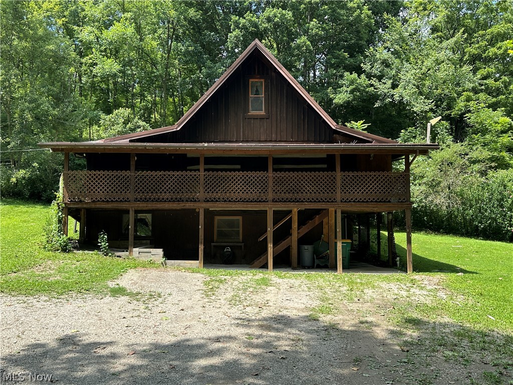 Welcome to this charming custom-built cabin, constructed in 1981 and nestled in a peaceful country setting. This unique story -and-a-half home offers the perfect blend of rustic charm and functional living. The main level features three comfortable bedrooms, a spacious eat-in complete with refrigerator and range, and an inviting open living room with an open rail staircase leading to the upstairs loft-  ideal for a home office, guest space, or cozy hangout space. A convenient half bath is located on the main floor, while the full bath and mudroom are just off the kitchen. The full walk-out basement provides endless possibilities with a partial kitchen setup, laundry area complete with W & D, generous storage space, and two separate walk-out entrances, making it ideal for hobbies or finishing for additional living space. Outside, you will find everything to enjoy country living, including a barn with a small barn-yard a smokehouse shed, and an additional storage shed. A metal roof estimated to be approx 7 years old. Seller is selling in AS IS condition, and seller does not own mineral rights.