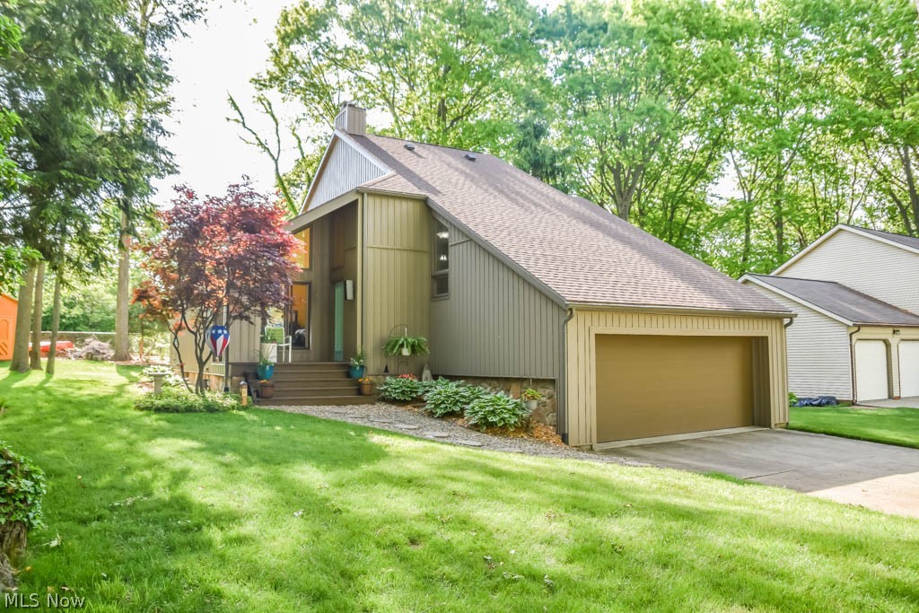 Don't wait to see this beautifully updated 4 bedroom home in North Canton's Eastwoods neighborhood! The contemporary architecture has been thoughtfully enhanced with so many excellent features including a new kitchen with butcher block island with seating, quartz counters, subway tile backsplash, and black stainless appliances. A sliding patio door opens to a partially covered deck and amazing backyard with mature trees and a shed for storage.  Newer laminate flooring flows from the kitchen into the vaulted great room with a fireplace and huge windows that let in an abundance of natural light.  In the hall to the attached 2 car garage, you'll find a convenient 1st floor laundry and a guest bath.  The lower level has been finished to add a rec/family room, as well as a bedroom with egress window, double closet, and a full bath.  Upstairs are 3 more bedrooms and 2 full bathrooms, one of which is the owner's suite with a walk-in closet and en suite bath.  This home is situated on a cul de