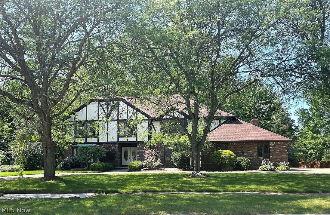 Spacious 4-bedroom 5-bath Tudor home. Let the beauty of this home unfold as you enter the Foyer, hardwood floors & crown molding welcome you.  The Kitchen boasts granite counter tops & stainless steel appliances and opens up nicely to a step down Family Room complete w/fireplace, perfect to visit family & friends. As you look out the rear of the home, it has the feel of your own nature retreat as the wooded lot drops down to a small ravine and a quaint stream. You'll never believe that you're in town on this over 1-acre double lot.  Enclosed porch on the back of the home to enjoy the outdoors bug-free and a large deck and patio. The 2158 SF finished basement is the ultimate man cave, complete with full bar and yet another fireplace, perfect for adults and kids alike. It even has a dance floor, workshop and other storage rooms.  Don't miss the opportunity to own your own personal retreat.