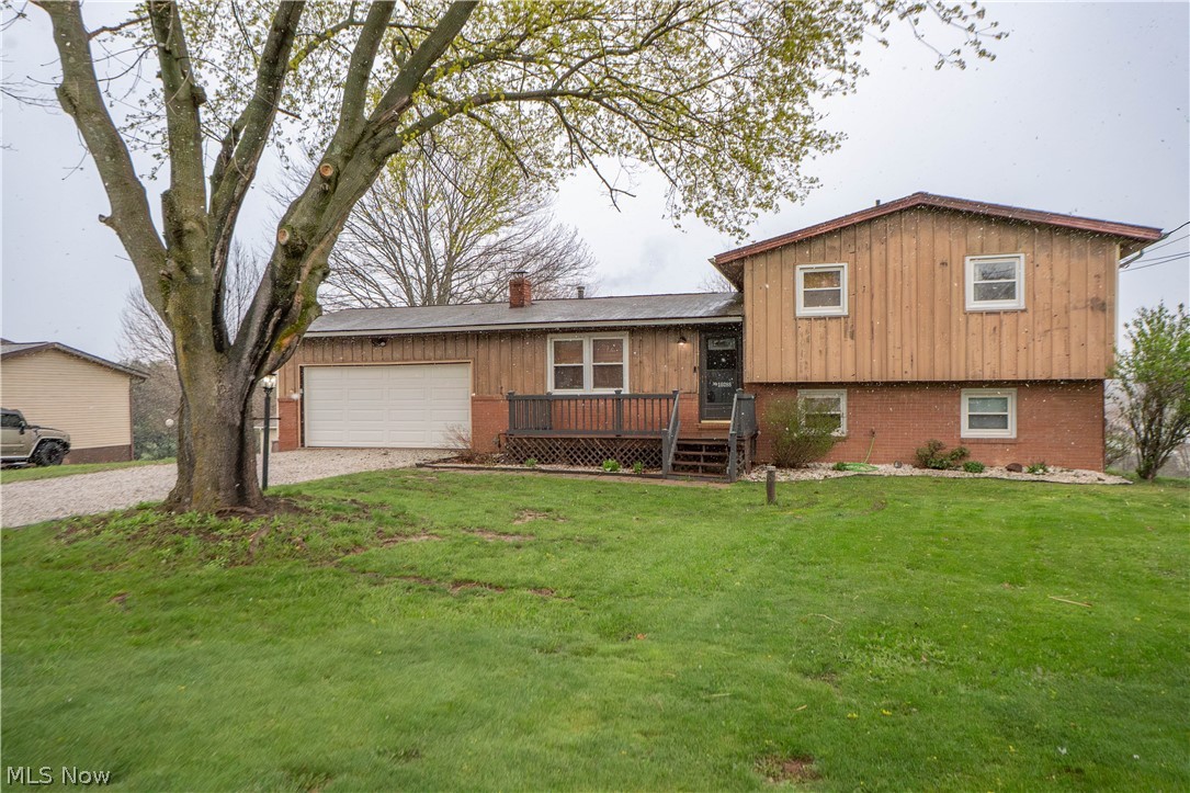 Step inside this inviting split-level home and discover a layout that flows comfortably from one space to the next. A welcoming front porch leads into the bright living room, where natural light and updated flooring create a warm first impression. Connected is the dining room offering a charming built-in shelving and an easy connection to the kitchen, giving the main level a functional feel for everyday living and entertaining. The kitchen features ample cabinet space, a pantry, and stainless steel appliances. Upstairs, you'll find 3 comfortable bedrooms, one being the primary bedroom with a large closet, they share a full bath featuring a shiplap wall and a shower tub combination.  The lower level adds even more living space with a spacious family room, fireplace, sliding door to the back patio, a second full bath with tile shower, and a flex room that works well as an office, gym, playroom, or possible 4th bedroom. The unfinished basement adds laundry, storage, utility space, and even more functionality. Outside, enjoy the patio, large backyard, and 2-car attached garage, all set on a generous half-acre lot. Recent updates include replacement windows, flooring, garage door, Andersen slider door to back patio in 2024, and hot water tank in 2025. A well-kept home with flexible living space inside and room to enjoy outside.