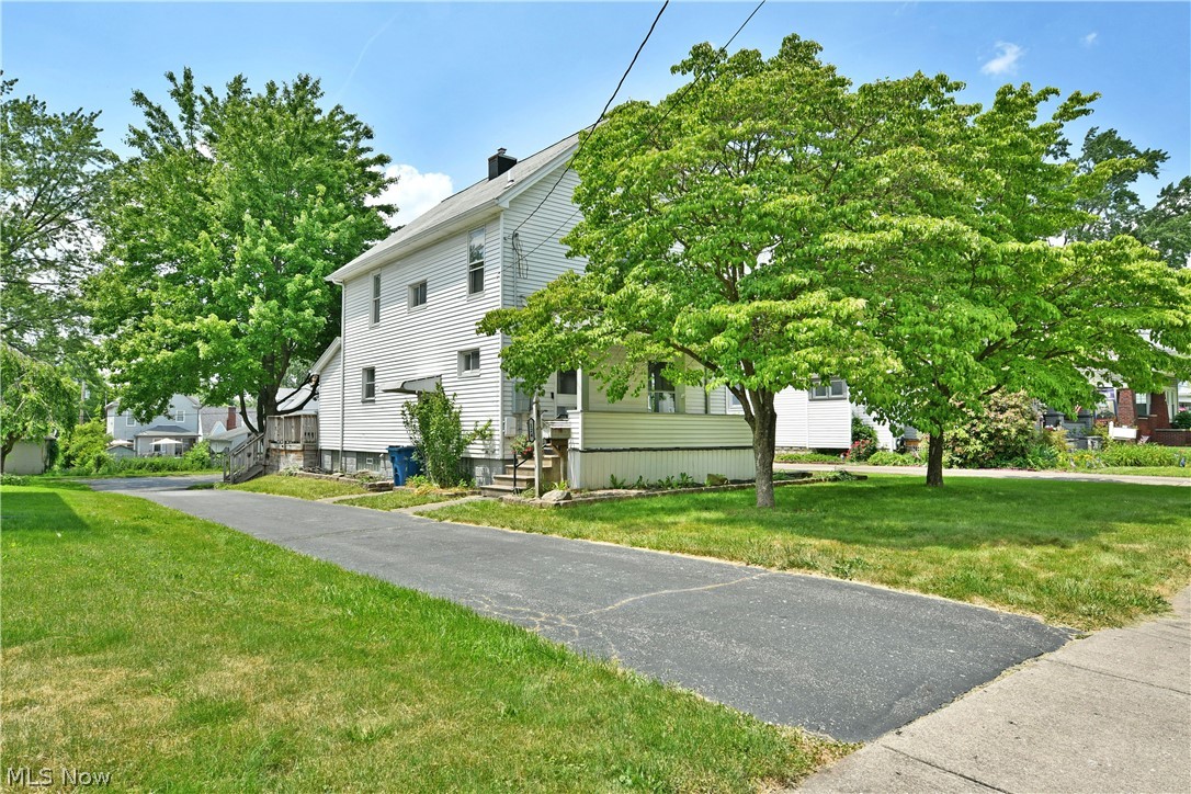 Three floors of inviting living space await in this impressively spacious Niles home! If you've been searching for extra room in an attractive, move-in-ready package, this charming residence deserves a spot at the top of your list. Nestled in a cozy neighborhood just minutes from shopping and dining, the property enjoys a sense of privacy thanks to its mature trees and welcoming covered front porch. Around back, a huge two-tier deck provides the perfect setting for entertaining, relaxing, and enjoying summer gatherings. The blacktop driveway extends to a detached two-car garage, offering plenty of space for parking and storage. Step inside to a bold foyer highlighted by a striking staircase, while slate-colored hardwood-style flooring flows throughout the main level. The spacious living room is ideal for entertaining, and the adjacent formal dining room is filled with natural light from its large windows. Navy-colored cabinetry adds character to the kitchen, where ample counter space makes meal preparation a breeze. A casual dining nook overlooks the backyard, while a convenient storage room serves as a walk-in pantry. Upstairs, three generously sized bedrooms each offer multiple windows and ample closet space. A full-set bath joins them as it features a hidden staircase to the finished third-floor attic, making a great play area or bonus room. Completing the home, the basement level includes laundry services, utility access, and additional bath provisions. Updates include: hot water tank 2020, electrical panel 2025, waterproofed basement, vinyl replacement windows, and more. Plus a one-year home warranty!