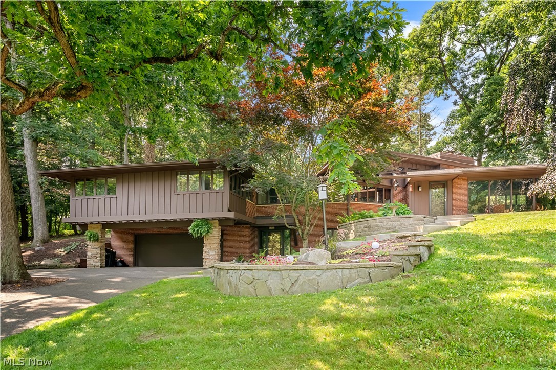 Nestled on 5.3 private acres in the heart of Jackson Township, this authentic Mid-Century Modern home offers timeless architecture, exceptional natural light, and a peaceful setting. Surrounded by mature trees and abundant wildlife, the property offers a unique combination of privacy, convenience, and year-round natural beauty. From spectacular fall colors to peaceful snow-covered winters, every season offers a unique connection to the surrounding landscape. Designed to maximize natural light and capture the beauty of the outdoors, the home features expansive picture windows with scenic views from nearly every room. Original hardwood floors, a striking terrazzo entry, beautiful natural wood details, and iconic Mid-Century Modern design elements create warmth and character throughout. Recent updates include new exterior paint, new carpet, and an automatic Generac natural gas backup generator. Offering three bedrooms and two full bathrooms, the home combines distinctive architecture with comfortable living. In addition to the attached two-car garage, the property includes a detached two-car garage with electric, floor drains, one finished bay, and a drive-through work bay. A separate workshop/shed with sliding barn doors offers additional space for storage, hobbies, or future projects. Authentic Mid-Century Modern homes with acreage are incredibly rare, and this property offers the added convenience of being just minutes from Belden Village, shopping, dining, healthcare, and I-77. Whether you're searching for a private escape, a home that celebrates iconic architecture, or space to pursue your passions, this remarkable Jackson Township property offers a lifestyle unlike any other.