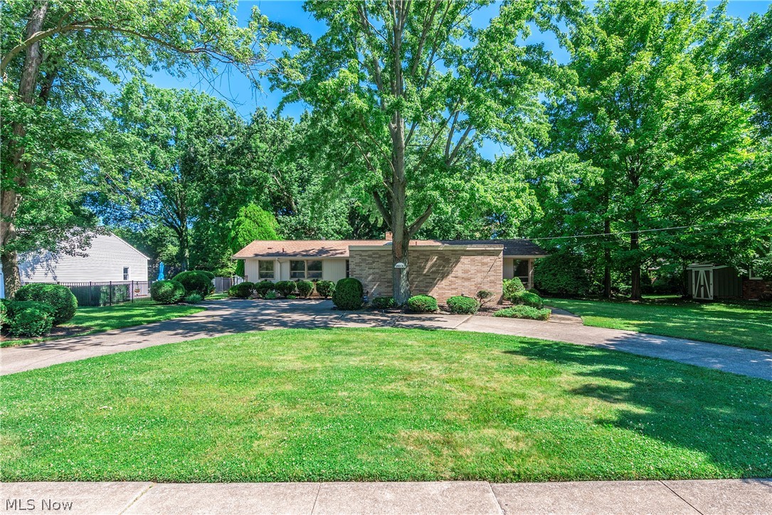 Lovely brick/cedar ranch home on sought after VALLEY lot with a mid-century vibe! Front porch and decorative glass entry door/sidelight opens into a spacious living room/dining room with light carpet/tile! Vaulted ceiling! Unique brick, 3/4 wall with wood, display shelf running the length of the top. Window wall to rear yard. OPEN kitchen with medium-stained wood cabinetry, tile flooring, light Formica countertops, built-in desk, pantry closet, skylight and cool, VINTAGE turquoise cooktop/double wall oven! Garbage disposal replaced in 2025! Open to cozy family room with hardwood flooring, brick, wood-burning fireplace with sandstone mantle and window wall to rear yard! Off the main hall is a UNIQUE split full bath with newer 4-ft. marble-look, replacement shower with new hardware and vanity/sink...other side of door is a second vanity/sink and toilet. A full bath off laundry room and a full/half bath off main hall. Hall linen closet! Two doors to rear yard off living/family rooms. Sizable wood-windows that let in tons of natural light! Mudroom/laundry room with utility sink and lots of storage cabinets off convenient, covered side porch; garage entrance, coat closet, closet stair-storage leading up to storage under the eaves. Two secondary bedrooms with wood-look, vinyl flooring/double closets! Master suite with THREE walk-up closets, 1/2 wall brick, decorative wall with display ledge, windows to rear...attached master bath with stall shower, double vanity (sink area and make-up area)! All appliances remain including a newer washer/dryer and newer full refrigerator in basement. LOWER LEVEL is very large...the whole footprint of the home! Finished area with carpet, woodwork, walk-in closet and half bath. The remainder is unfinished and divided into two areas. Oversized, attached, two-car garage with door opener and skylights for extra light! Full HVAC replacement in 2025! Paver patio to enjoy your semi-private rear yard. Good condition with lots of potential...