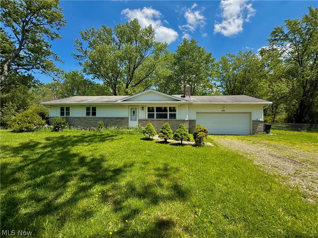Welcome to 4088 Lynwood Drive -- a spacious ranch tucked away on a dead-end street in Brimfield Township within Field LSD. Offering 4 bedrooms, 1.5 baths, 1,196 sqft and just shy of 1 acre on a double lot, this home combines updates with the opportunity to add your own finishing touches over time. Inside, you'll find an inviting layout with updated LVP flooring, carpeting, newer windows, fixtures, exterior doors, laminate counter tops, modern cabinetry, ample counter space, and an open flow into the dining area. The primary bedroom includes its own private half bath, while the updated full bath adds a fresh, modern feel. The attached oversized 2-car garage offers excellent storage and workspace potential, while the full basement provides additional room for recreation, hobbies, entertaining, or future finishing. Outside, enjoy the fully fenced backyard and peaceful setting with mature trees surrounding the property. Major improvements include an aeration septic system, A/C unit, and newer water softener system for added peace of mind. This home is ready for someone to come in and make it their very own. Conveniently located near shopping, dining, parks, and highway access while still offering privacy and space of township living on .92 acres.
