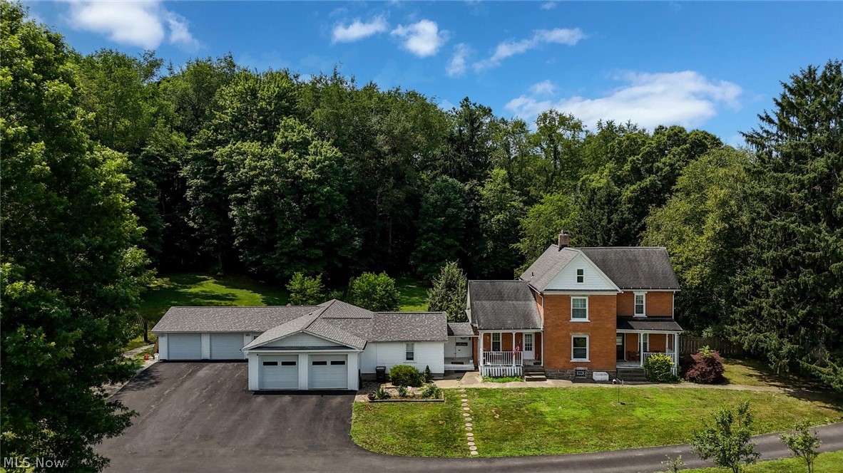 One of a kind opportunity!  Original 1904 farm house, additional living suite, 2 sheds & 2 attached & heated 2 car garages, on 2.5 gorgeous acres!  Main house was completely renovated, while still maintaining handsome original woodwork, hardwood floors & transom windows.  Huge eat-in kitchen offers tons of cabinetry, butcher block countertops, slate backsplash, ceiling fan, tiffany style light & all appliances included!  High ceilings continue into the sitting room, w/ a wall of intricate woodwork, pocket doors to the living room (currently used as bedroom) & fireplace.  Multiple original doors provide access to the 2 covered porches.  Don't miss the luxurious main floor bathroom!  Massive space with a floor to ceiling travertine shower, fantastic soaking tub & laundry closet!  The 2nd floor holds 3 comfortable bedrooms & 2nd full bath.  This unique bathroom features an enormous marble shower, original hardwood floor & custom antique vanity!  Walk-through closet connects to the primary bedroom too!  Now for the incredible guest suite!  Starting w/ an attached, heated & cooled 2 car garage, w/ skylights, water & finished hang out area!  Through the antique door into an amazing suite!  Gorgeous marble floors throughout.  Full bath off hallway w/ floor to ceiling marble, walk-in shower & solar tube.  Bedroom is partitioned off by reclaimed antique doors from a church in Massillon!  Primary bath has a walk-in closet & huge shower!  Dining room opens to the kitchen w/ skylight, paneled ceiling, massive island, stainless fridge, dishwasher, microwave & Viking range!  Utility closet doubles as a pantry too!  Living room is original to 1904, w/ a beautiful view of the neighboring farm!  The back yard is fenced in & full of peach, apple & pear trees!  A car enthusiasts dream, multi-generational living, rental income, Airb&b or run a small business, this property has endless possibilities! Property receives FREE GAS from neighboring well!  Ask for full update list- MUST SEE!