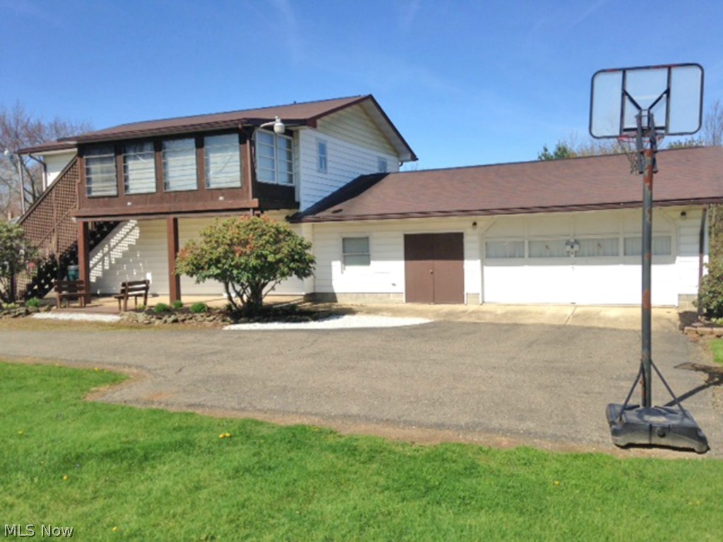 Unique property on large double lot. Lower level previously used as beauty shop with half bath, family room and attached 3 car over sized garage. Upper level has separate entrance with sun room, 2 bedrooms, kitchen, laundry and living room. Nice paved driveway. Zoned B-1 with additional single wide 1966 Fleetwood mobile home previously rented for $300 per month. It has gas heat. Main home is all electric with two electric meters.