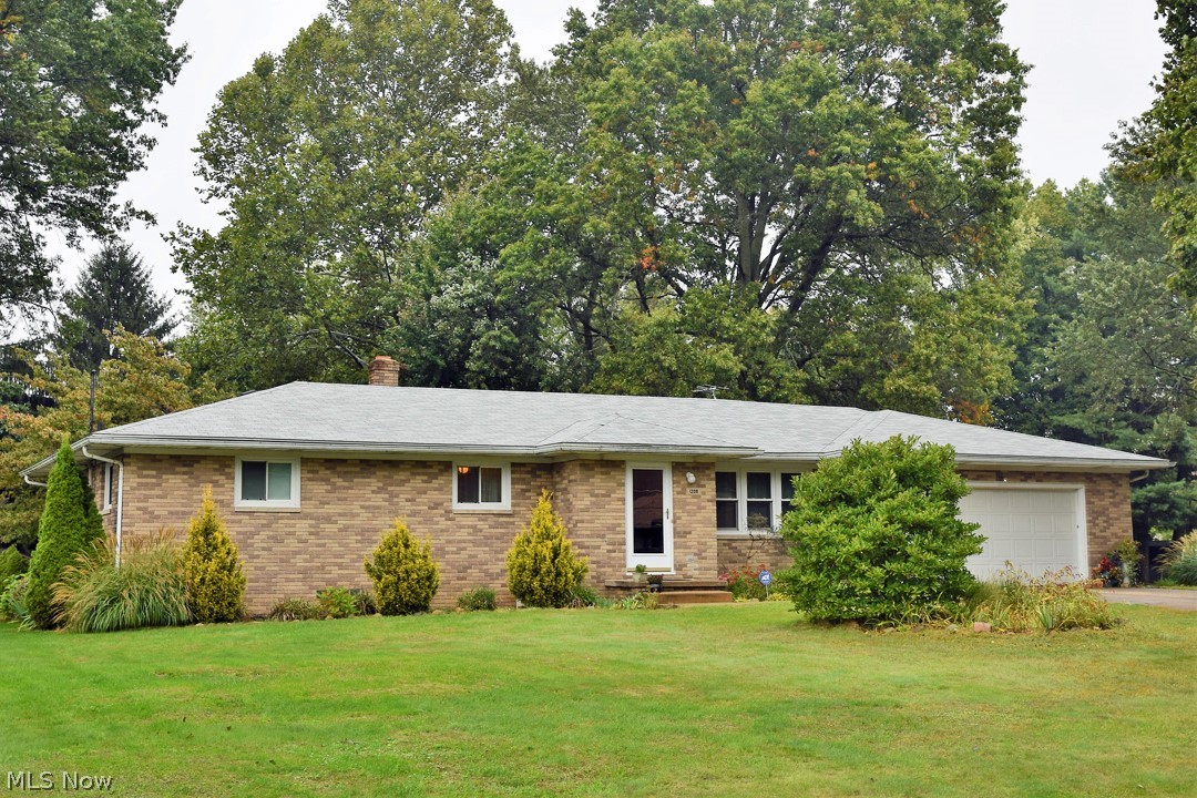 Beautiful brick ranch situated on .66 acres in Green Local School district! The main level of the home hosts three bedrooms, including the master with its own bathroom, a second bathroom, the front living room, and an eat-in kitchen with lots of cabinet space and a gas range. Sliding doors off the kitchen lead to the wonderful three-season room (which has all new windows & sliding glass door) which walks out to the concrete patio overlooking the back yard’s mature landscaping. Very nice yard which is fenced in and has a storage shed. Half of the basement is finished with a rec. room and a fourth bedroom. The other side of the basement offers lots of storage, laundry, and another functional newer shower. Oversized, heated two-car garage with two man door exits (new door and opener), and hot/cold water. Newer windows. New Roof. Move-in ready. Schedule your private viewing today!