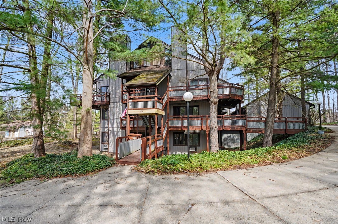 Enjoy the feeling of living in a private community surrounded by beautiful wooded views in every direction. This inviting one-floor condo offers the ease of living.  The spacious living room with gas fireplace is open into the dining area, where an abundance of windows allows for so much natural light. Sliding doors lead to a bright 3-season room — perfect for morning coffee or relaxing at the end of the day — while a second set of sliders opens to a generous deck overlooking the peaceful, natural setting. The kitchen is open to the dining area, offers a pantry and all appliances are included.   The two bedrooms are spacious and offer nice closet space with the bathroom featuring double vanities and a walk-in shower.  The laundry room offers additional storage, and the stackable washer and dryer convey for added convenience. A detached one-car garage is located just a short walk from the entrance, with just a few steps into the front door.  Enjoy access to the two pools this summer and embrace low-maintenance living in a serene, wooded setting.  Monthly fee includes heat, water, trash, snow, landscaping, association insurance, reserve fund and exterior maintenance.
