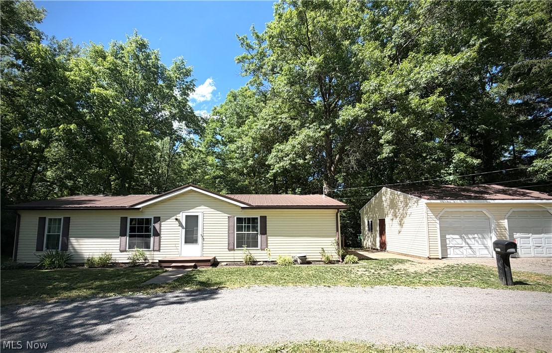 Welcome to your own yearlong peaceful retreat. One story living provides convenience and accessibility.  The Relaxing back yard has an open deck looking over a tranquil creek, and firepit to spend your evenings fireside. Open living area features updated laminate flooring to dining area with sliding door to your back deck. Primary bedroom with tastefully updated primary bathroom. Guest bathroom is also being completely remodeled. Please envision the work to guest bathroom that will be completed shortly with the AI generated photos including all the products being used in the remodel. Additionally, there a 2 more bedrooms, and laundry area all on one floor. 2 car detached garage and u-shaped drive provides storage and parking.