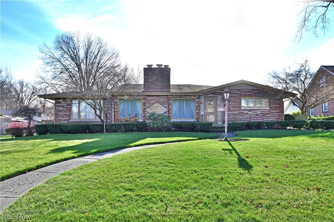 Prepare to be amazed at the astounding amount of living space this massive Youngstown ranch has to offer! An equally impressive exterior sets the mood as the all brick construction stands squarely on the oversized lot, showcasing its concrete driveway leading to a 3 car attached garage and hidden rear patio, complete with a central planter brick privacy wall. A covered patio marks the side entrance leading to the updated kitchen, while the formal entry places you at the main hallway, peering into the spacious living room, elegantly trimmed in lush carpets and tapestry alike with decorative lighting that can be found in each living quarter. Highly sculpted entry ways lead past a central dining area and posh parlor to converge on the galley kitchen with its ample countertop space and additional casual dining area. A lower family room looks on with a stone accent wall with fireplace. Three inviting bedroom branch from the main hall to include a master suite with full private bath, and a s