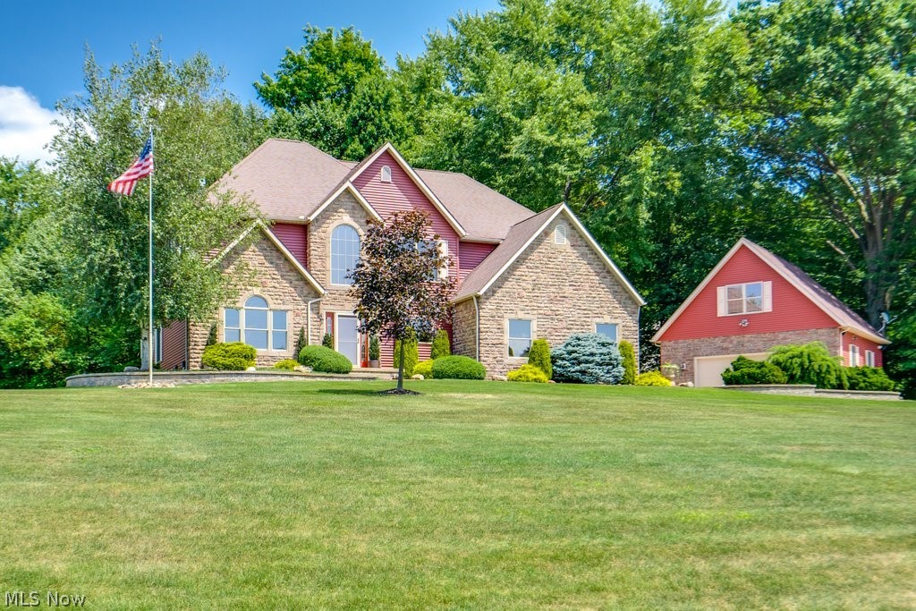 Spectacular custom home situated on a private 1.5-acre wooded lot in the highly desirable Windy Hill Estates of Wadsworth! Enjoy paved streets, streetlights, and a prime location just minutes from SR 585, SR 21, I-77, and I-76.

This stunning home offers approximately 2,738sq. ft. with 4 bedrooms, 2 full baths, and 2 half baths. The spacious owner’s suite features a sitting area, walk-in closet, and luxurious bath with a garden/whirlpool tub. Highlights include a dramatic two-story foyer and great room, 9-foot ceilings, sunroom, walk-in pantry, and attached 3-car garage. The finished lower level adds approximately 1,250 sq. ft. with a large recreation area, office, and half bath.

Step outside to an incredible backyard featuring a 1,450 sq. ft. stamped concrete and Unilock paver patio, custom retaining walls with built-in lighting, natural gas fire pit, and hard-piped Charbroil gas grill—perfect for entertaining.

A detached 2.5-car garage mirrors the home’s architecture with stone, siding, rooflines, and Pella windows. Heated and air-conditioned with 12’ ceilings, custom finishes, ceramic tile, half bath, separate security system, and pre-wired 220V EV charging. Upstairs is an impressive 20’ x 30’ entertainment room with bar, 110” projector screen, projector, and custom surround sound.

Additional features include a new furnace and central A/C (2025), Bradford White tankless water heater (2022), Hunter irrigation system, security cameras, Sunsetter automatic awning, Pella windows and doors, oversized driveway with Gorilla Slam basketball court and lighting, custom landscaping, Heat & Glo stone fireplace, new carpet (2021), freshly painted interiors, tinted front windows, gutter guards, vinyl privacy fencing, exterior speakers, telescoping flagpole with spotlight, and a 12’ x 20’ barn nestled in the woods with a private gravel path.

This meticulously maintained property offers luxury, privacy, and exceptional amenities rarely found in one home.