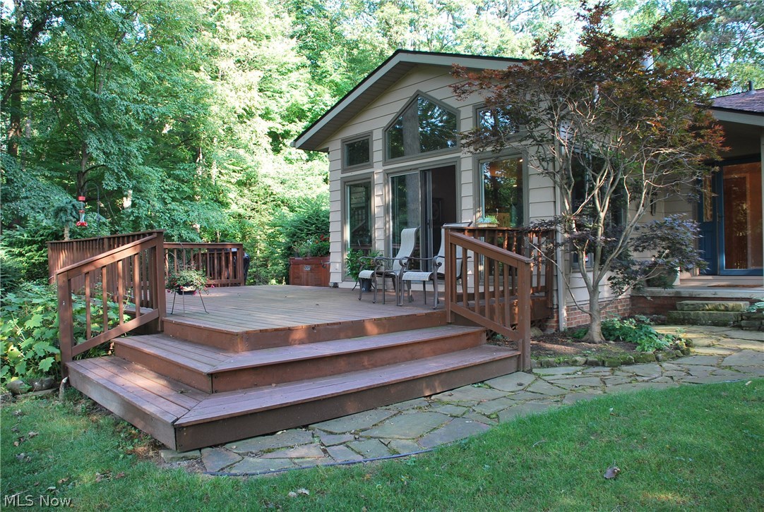 This is TRULY the Home of Your Dreams! Water views from the front & the back of this home with almost 3 acres of land; private & direct lake access with a ton of water frontage, dock/mooring available with a large yard barn tucked in the woods. Relax on the huge back deck over looking the tranquil setting with mature trees, lots of wildlife & birds, plenty of yard & even more woods! This home has 3 levels & a basement for storage & utilities. The 2 car garage is oversized, has a HUGE storage access above it & steps to basement! Main level has both  Front Living Room with water views through the numerous windows & back Great Room that is vaulted with the perfect view through the wall of windows of the back yard & water! The custom Kitchen has tall cabinetry & a great layout for cooking as well as entertainment with the eating bar separating the Dining Area. This open concept lends itself to a great flow for both family & entertaining! There are numerous doors to the exterior & the deck