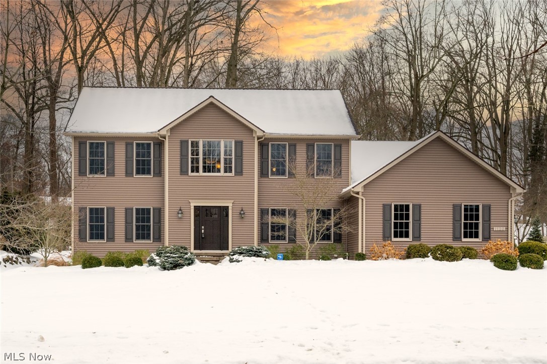 First time offered! Fall in love with this stately colonial nestled in one of Kent's best kept secrets and highly sought after University Woods! Situated on a generous 1/2 acre lot with a nice flat back yard, enjoy gorgeous wooded views year round from the amazing patio! Enter through the new custom front door into a 2 story foyer w/tiled porcelain flooring, 9 foot ceilings. Solid french doors lead to a first floor office/living room, featuring 3/4" hickory flooring and tray ceiling. The kitchen is a true gourmet's dream! Beautiful maple cabinets in rich cherry stain, 10 foot granite counter with seating for 5! Cook up a storm on the SS Fisher & Paykel 5 burner gas stove with a custom SS hood imported from Italy! Double oven w/convection and microwave, and a huge pantry with roll-out shelves! Open concept dining area flows into the great room with hickory flooring and stone front gas fireplace + a bright 4 season sun room! Kitchen/dining/foyer/sun room all have porcelain flooring! The