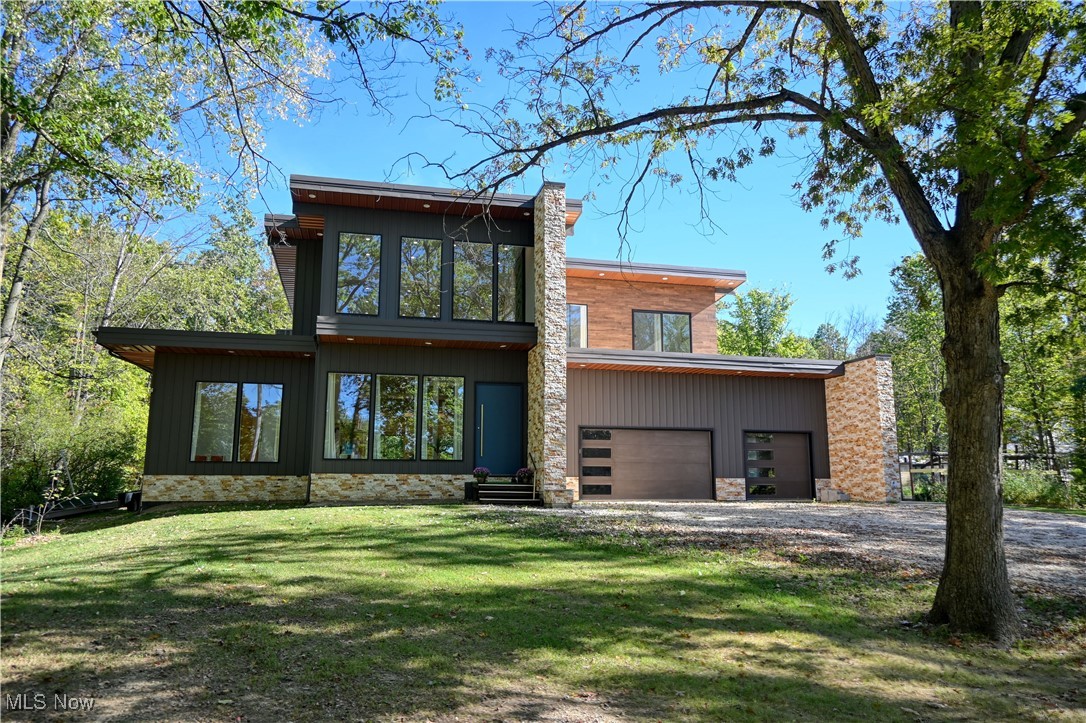 Experience the ultimate in contemporary living at 4137 Foskett Road, Medina, Ohio 44256—an architecturally distinct model home built in 2023 and set on 2.8 serene acres. This residence showcases a dramatic open floor plan with five spacious bedrooms and four luxurious full bathrooms, framed by floor-to-ceiling windows that fill every corner with natural light. Entry is through a one-of-a-kind mahogany door that hints at the quality found throughout the home.

Step into the chef’s kitchen—designed for culinary excellence—with a commercial-grade range, real hardwood 48" cabinets, striking marble countertops, and an oversized walk-in pantry. The main-floor primary suite is a true retreat, featuring a custom floating bed and a spa-inspired bathroom with heated floors, waterfall faucets, floating cabinetry, a two-person hot tub, and a zero-threshold shower designed for indulgence.

Upstairs, four bedrooms overlook the wooded backyard and share a spacious landing area perfect for relaxing or gathering. The cutting-edge roof design integrates a hidden drainage system for a sleek profile without gutters. Outdoor living shines with a vast 5,000+ sq ft walk-on patio surrounding the upper floor.

The finished basement is a true entertainment hub, with a dedicated theatre room, gaming lounge, custom marble-and-wood bar with lighted epoxy countertops, and ample room for events. Enjoy the convenience of a heated three-car garage and a private, lush setting perfect for gatherings or peaceful escapes.

The backyard offers a covered entertaining area, raised gardening beds, chicken run, and a cozy fire pit nestled in the trees. 

4137 Foskett Road is a rare find in Medina—a modern, open-concept masterpiece packed with distinctive amenities for luxury living both indoors and out.
