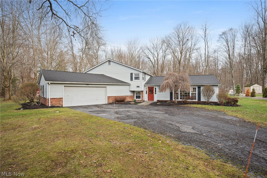 Set on 1.18 wooded acres in Bainbridge’s sought-after Pilgrim Village community, this home offers central A/C, a whole-house generator, 2-level deck & access to exceptional community amenities. Located in the Kenston School District, the property provides a serene setting surrounded by mature trees while remaining part of an inviting lake community whose residents enjoy access to Lake Taylor, w/ a sandy beach, swimming, fishing, kayaking, paddleboarding, volleyball, BBQ area & a covered pavilion. The home features 4 bedrooms, 2.5 baths, 2,832 sq ft, hardwood flooring, and flexible living spaces including a spacious family room w/ a brick fireplace, an open living room & dining area w/ lots of natural light & built-in cabinetry & shelving, and a versatile bonus room that can be used as a home office, playroom, or exercise room. The kitchen includes double wall ovens, plenty of cabinet space & access to the deck & parklike backyard, w/ garden boxes, a firepit, shed & playset. A large shared mudroom/laundry room with built-in storage cubbies and an attached 2-car garage offer added convenience. The primary suite has a walk-in closet & an updated en-suite bath w/ walk-in shower. Recent updates include: Replaced A/C (2020), water heater (approx 2023), installed whole-house generator (2019), shed (2019), updated master bath (2022), replaced half bath vanity/sink (2020), added wall to create mudroom w/ cubbies and bonus room (2020), installed PVC main line to sewer (2024), replaced clay drainage pipe from footer drain w/ PVC (2020), installed shelving in multiple rooms and garage (2020-2024), replaced flooring in family room (2020), upstairs hall & stairs carpet (2019), painted throughout (2020), and more. INCLUDED are ALL kitchen appliances, washer/dryer, whole-house generator, Ring doorbell, and playset. Office desks can stay if buyers want them. Conveniently located near US-422, OH 306, shopping, restaurants, schools, parks, and other local attractions.