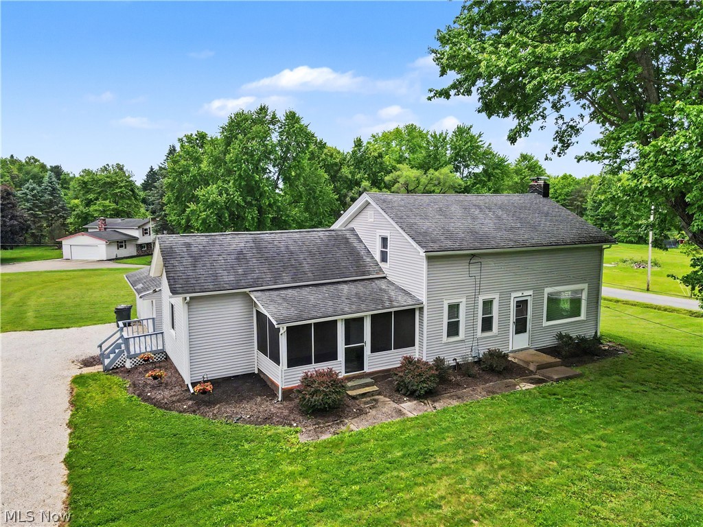 Situated on 1.4 scenic acres, this fantastic farmhouse combines timeless character with modern updates. Before stepping inside, you'll appreciate the beautiful outdoor space featuring a fire pit, a large outbuilding with electricity, a wood deck, and a three-season porch perfect for enjoying Ohio summers. Inside, you'll love the bright and inviting feel that preserves the home's farmhouse charm while offering today's conveniences. The updated kitchen features white cabinetry, butcher-block countertops, recessed lighting, LVT flooring, and stainless-steel appliances. The kitchen opens to the dining area, which has been refreshed with new LVT flooring, fresh paint, and updated lighting. Just off the kitchen is a cozy family room with newer carpet and lighting, while the spacious living room offers abundant natural light and a beautiful wood-burning fireplace. The first floor also includes an updated full bath with new flooring and lighting, as well as a remodeled laundry room with a large storage closet. Upstairs, you'll find three bedrooms and an updated half bath. The spacious primary bedroom features newer carpet, fresh paint, and two walk-in closets. The second bedroom includes built-ins and its own walk-in closet. The attached garage provides space for up to four vehicles, or a workshop/additional storage. The outbuilding with electric is ideal for storing kayaks, boats, four-wheelers, lawn equipment, and more. Major updates include: water softener system (2022), half bath (2023), kitchen (2025), electrical panel and wiring (2025), drywall and insulation improvements (2025), full bath (2026), laundry room (2026), and gutters (2026). Conveniently located near major highways, downtown Kent, shopping, dining, and beautiful Lake Hodgson, this move-in-ready home offers the perfect blend of charm, character, and modern updates. Just move in and enjoy!