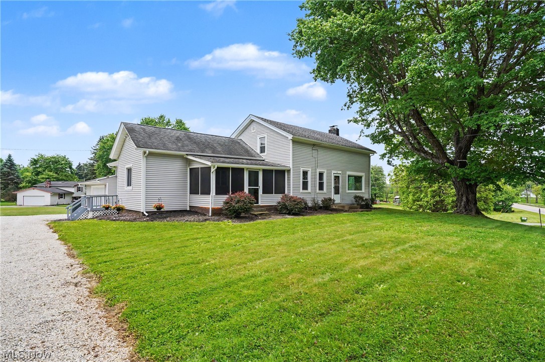 Situated on 1.4 scenic acres, this fantastic farmhouse combines timeless character with modern updates. Before stepping inside, you'll appreciate the beautiful outdoor space featuring a fire pit, a large outbuilding with electricity, a wood deck, and a three-season porch perfect for enjoying Ohio summers. Inside, you'll love the bright and inviting feel that preserves the home's farmhouse charm while offering today's conveniences. The updated kitchen features white cabinetry, butcher-block countertops, recessed lighting, LVT flooring, and stainless-steel appliances. The kitchen opens to the dining area, which has been refreshed with new LVT flooring, fresh paint, and updated lighting. Just off the kitchen is a cozy family room with newer carpet and lighting, while the spacious living room offers abundant natural light and a beautiful wood-burning fireplace. The first floor also includes an updated full bath with new flooring and lighting, as well as a remodeled laundry room with a large storage closet. Upstairs, you'll find three bedrooms and an updated half bath. The spacious primary bedroom features newer carpet, fresh paint, and two walk-in closets. The second bedroom includes built-ins and its own walk-in closet. The attached garage provides space for up to four vehicles, or a workshop/additional storage. The outbuilding with electric is ideal for storing kayaks, boats, four-wheelers, lawn equipment, and more. Major updates include: water softener system (2022), half bath (2023), kitchen (2025), electrical panel and wiring (2025), drywall and insulation improvements (2025), full bath (2026), laundry room (2026), and gutters (2026). Conveniently located near major highways, downtown Kent, shopping, dining, and beautiful Lake Hodgson, this move-in-ready home offers the perfect blend of charm, character, and modern updates. Just move in and enjoy!