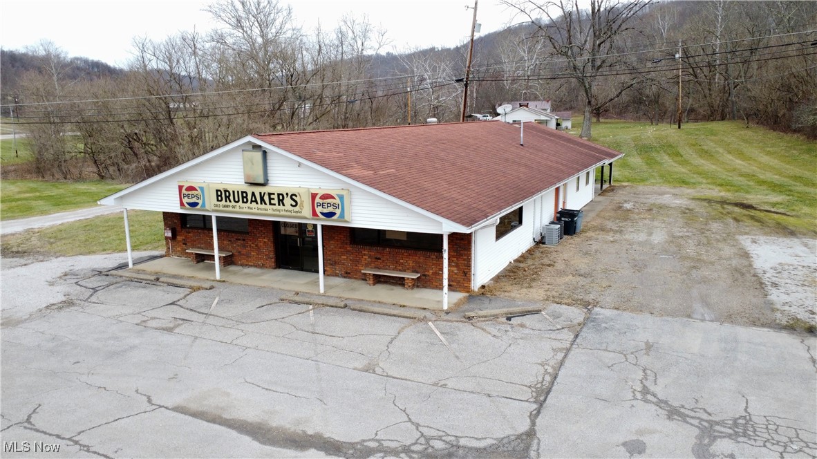 Located just outside Powhatan Point along East Captina Highway (State Route 148), this former country store offers a rare mixed-use opportunity with strong income and business potential. The main commercial building features approximately 2,800 square feet and was previously operated as a market, with shelving and coolers still in place, making it well-suited for retail, carry-out, restaurant, catering space, pet grooming, or other small business uses. Attached to the building is a 2-bedroom, 1-bath apartment with a spacious living area, eat-in kitchen, and utility room, ideal for owner-occupancy or rental income. The building sits on a concrete slab and has York Township water with a private septic system. Located minutes from the marina and golf course, this property blends rural charm with commercial flexibility and is being sold As Is, with no repairs to be made by the seller.