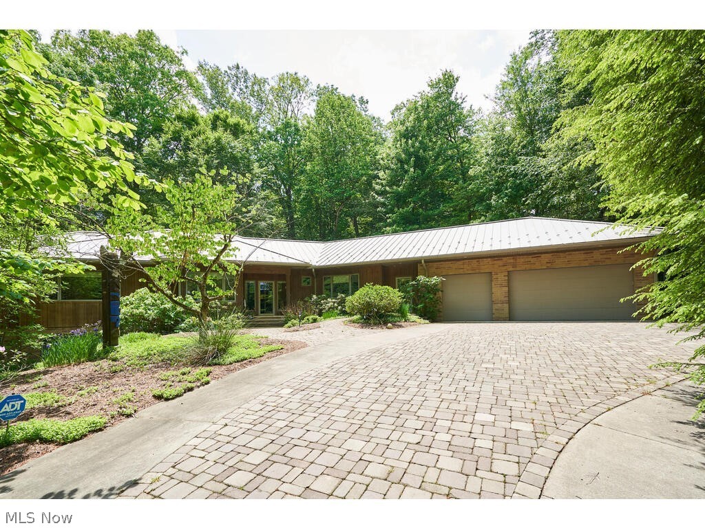 Natural oasis on nearly 2 acres with 1st floor living and panoramic views from every room! This custom-built ranch is tucked away and secluded in Merriman Woods! You’ll feel the exclusive privacy from your first drive over the paver bridge and driveway to your own escape.  Open concept 1st floor features hardwood floors milled from the oak trees located on the property prior to build (as are the int. doors), spacious living room w/ fireplace & wet bar w/ ice maker open to the dining room area w/ door to rear screened in porch, functional kitchen with maple cabinets, quartz counters, breakfast bar, and new double oven, gas range & dw (’21), master suite w/ 8x8 WIC, private study w/ built-in shelving, jacuzzi & walk-in shower, add’l ensuite bedroom with WIC, half bath, and access to master bath, office, laundry room w/ newer washer and dryer that stay, mudroom & 3 car garage w/ double doors to backyard. Take either of 2 separate stairwells down to partially finished walk-out lower level