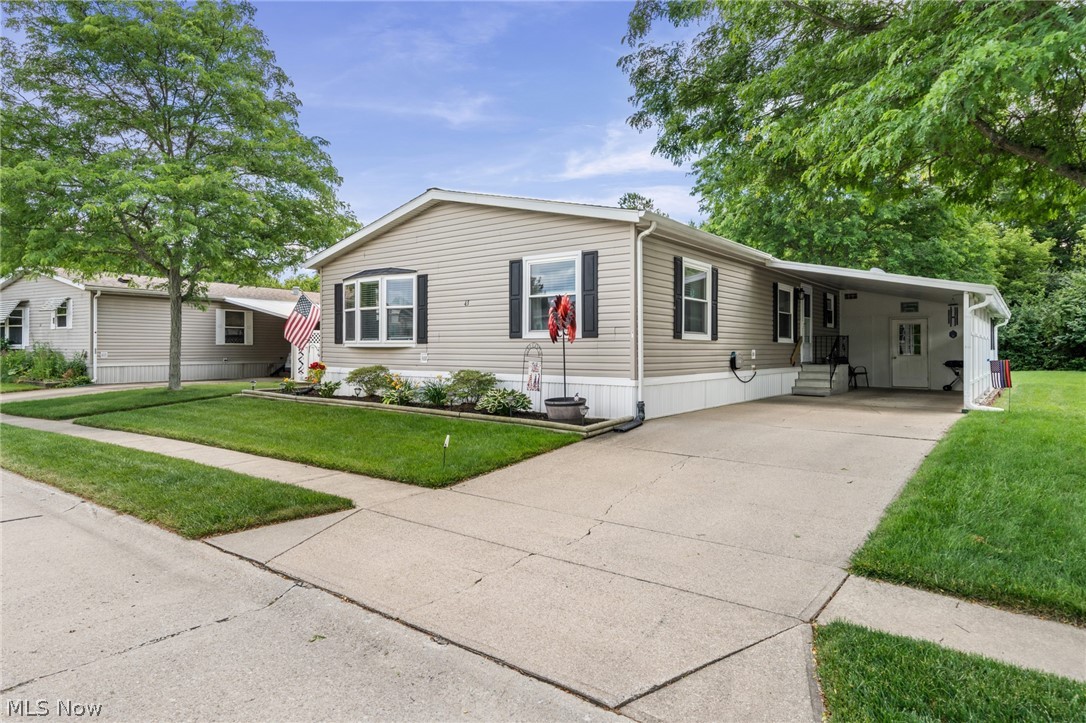 Enjoy carefree 55+ living in this beautifully maintained double-wide mobile home, tucked away in one of Olmsted Township's hidden gems! The spacious living and dining room features vaulted ceilings and sliding doors that open to a relaxing screened-in sunroom overlooking a private wooded setting.

The sun-filled eat-in kitchen offers a center work island, walk-in pantry, abundant cabinetry, and generous counter space—perfect for everyday living and entertaining. The generous owner's suite includes a private full bath, separate walk-in shower, and ample closet space. A second spacious bedroom, plus a versatile office/den that could serve as a third bedroom, provides flexibility to fit your lifestyle.

Additional highlights include a covered carport and attached storage area for added convenience. Recent update include a new furnace and central air (2022), carpeting, updated lighting fixtures, faucets, and a carport wall enclosure.

Small pets are welcome! Enjoy the easy lifestyle offered by this premier community featuring a gated entrance with gatehouse management, on-site management, walking paths, shuffleboard courts, bocce ball, a social hall, and more. Conveniently located adjacent to shopping and everyday amenities.

Move right in and start enjoying the leisure lifestyle you've been looking for—seeing is believing!