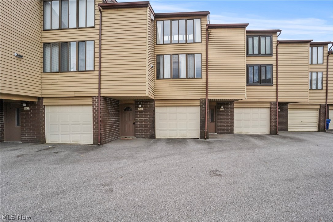 Here is a multi tiered Townhouse Condo located in a quiet community with close proximity to Portage Lakes, shopping, restaurants, and the highway. The lowest level has the foyer entrance, a laundry/utility area, a separate entrance from the single car garage and an open staircase to the main level. On this main level the floor plan is open and encompasses a large living room/ dining room combo, a galley kitchen and sliders to the deck porch. This condo is rustic and charming with exposed brick walls, large windows bringing natural light and an expansive wood beamed ceiling. There is a metal spiral staircase to the third level that includes the  spacious loft bedroom and full bathroom. 
The foundation of this condo has shifted slightly creating some unevenness that can be detected when walking on the main floor. Structural report available in the supplements. This is a great opportunity to own a reasonably priced condo in a well maintained community.