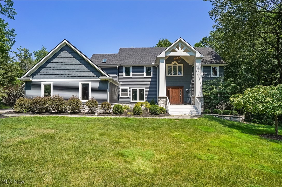 Welcome to your private estate nestled on a rare 6-acre wooded lot in Hudson! This stunning colonial offers over 4,400 sq ft of finished living space, blending timeless design with modern comfort. A welcoming front porch invites you in through a dramatic two-story foyer with a split staircase. The main level features a natural flow between the formal living room and dining room, where a wall of windows offers breathtaking views of the wooded property. The bright white kitchen boasts granite countertops, stainless steel appliances, and an island with seating for three. An eat-in area connects seamlessly to the spacious family room, creating an open-concept layout perfect for everyday living and entertaining. The family room is a showstopper with its white fireplace, vaulted ceiling with wood beams, and a stunning wall of windows that fills the space with natural light. Also on the first floor: a dedicated office, a powder room, and a finished laundry/mudroom with custom-built lockers and extra storage, located just off the attached 3-car garage. Upstairs, the primary suite features a large walk-in closet and a spa-like ensuite bath with a luxury walk-in shower. Three additional bedrooms and a full hall bath complete the second floor. The finished lower level offers over 1,200 sq ft of additional living space, including a custom-built bar made from reclaimed barn beams—ideal for entertaining or relaxing.
Step outside to enjoy a two-tiered back deck overlooking your private backyard oasis. A newly built outbuilding provides space for up to 4 additional vehicles or a dream workshop. It features a cedar plank ceiling, a loft, and is plumbed for water and gas. Nearby, you’ll find a greenhouse and chicken coop for added outdoor charm.