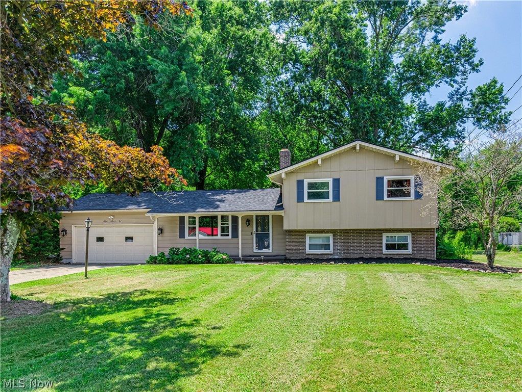Welcome to this beautifully maintained 4-bedroom, 1.5-bath split-level home situated on a picturesque, park-like lot in the heart of Doylestown! Offering a spacious and functional floor plan, this home blends character, comfort, and modern updates throughout. Step inside to soaring vaulted ceilings with exposed beams, abundant natural light, luxury vinyl flooring, and an inviting open-concept living and dining area. The spacious kitchen features stainless steel appliances, ample cabinetry, generous counter space, and overlooks the dining room with sliding doors leading to the large backyard deck—perfect for indoor and outdoor entertaining. The private lower-level primary bedroom provides a quiet retreat and half bath, while the finished lower-level family room showcases a stunning shiplap entertainment wall, creating the ideal space for movie nights, game days, or relaxing with family. Upstairs, you'll find three additional generously sized bedrooms and a beautifully updated full bath featuring a stylish vanity, contemporary lighting, and a subway tile shower surround.  Outside, enjoy your own backyard oasis complete with a spacious deck, mature shade trees, storage shed, and an expansive yard with plenty of room for recreation, gardening, or entertaining. The attached two-car garage and oversized driveway provide abundant parking and storage. Located in a desirable Doylestown neighborhood close to schools, parks, shopping, and dining, this move-in-ready home offers the perfect combination of space, style, and privacy. With its unique layout, beautifully updated living spaces, and incredible outdoor setting, this is one you won't want to miss. Schedule your private showing today!