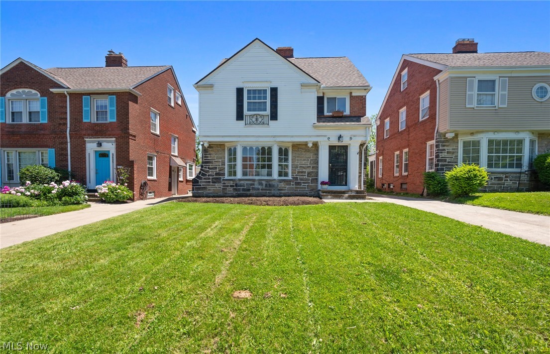 Welcome home to this beautifully updated three story Shaker Heights Colonial that effortlessly blends classic character with sophisticated modern updates. A welcoming entry guides you into a bright and airy living room anchored by a large architectural bay window that bathes the space in gorgeous natural light. Rich, dark hardwood floors flow openly from the living space into a formal dining room, creating a seamless environment for entertaining. From the dining area, step into a beautifully remodeled eat in kitchen complete with sleek quartz countertops, crisp white shaker cabinets, matching gold hardware, and stainless steel appliances. A tastefully updated half bathroom finishes the main level. Upstairs, the second floor features a gorgeous full bathroom with premium custom tilework along with three comfortable bedrooms. One of these bedrooms opens directly onto a private rooftop patio, providing a peaceful outdoor retreat overlooking the property. Continuing upward, the third floor is dedicated entirely to a spacious primary suite featuring a recessed built in bookshelf and its own private full bathroom beautifully designed with a subway tile tub surround and a modern vanity. Downstairs, the finished basement functions as a spectacular rec room or family room, fully carpeted with clean white wainscoting and featuring a cozy stone front fireplace alongside an abundance of extra storage room. This home also features a new hot water tank, electrical, and plumbing updates throughout. Sliding glass doors open out to a pleasant backyard equipped with a brand new built detached two car garage. This exceptional property perfectly captures the timeless charm of Shaker Heights, offering tree lined streets and an unbeatable location just steps away from world class schools, vibrant local shopping at the Van Aken District, rapid transit, and beautiful community parks!