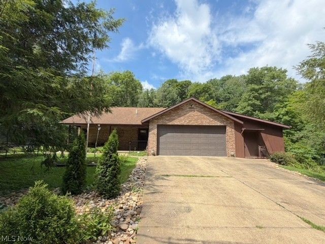 This beautiful brick ranch is tucked away on a .59-acre private lot in an ideal Wilkshire Hills location. Featuring 3 bedrooms, 3 full baths, a first-floor laundry room, and a full finished walk-out basement, this home has room for everyone. Step inside to an inviting open-concept floor plan with tasteful updates throughout. The living room has a gas fireplace while the eat-in kitchen has custom cabinets and Corian counter tops. Patio doors lead to a screened-in porch and wraparound deck overlooking the peaceful wooded backyard, creating a relaxing, private retreat you can enjoy year-round. The master suite has an en-suite bath with a spacious double shower and a walk-in closet. The lower level has the 3rd bedroom, a family room and bar area great for entertaining, and the 3rd full bath. There is a 2-car attached garage that has a separate workshop, pull down steps to the attic for additional storage, and a central vac perfect to keep your cars clean. Outside is a welcoming covered front porch, a large storage shed, and a sunny meadow that would be ideal for a garden. This property is in a peaceful country atmosphere while remaining just minutes to the highway for an easy commute. Recent updates include all new laminate flooring, new paint and fixtures, a brand-new high efficiency gas furnace with central air, and a tankless hot water heater.