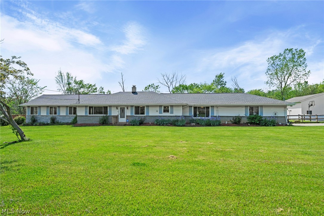 Tucked away on 1.51 private acres in the heart of Strongsville, 19740 Benbow Rd offers the perfect mix of peaceful country-style living with the convenience of city amenities just minutes away. This sprawling ranch features 4 spacious bedrooms, 2.5 bathrooms, multiple living areas, and exceptional indoor/outdoor entertaining space designed for today’s lifestyle. The updated eat-in kitchen serves as the centerpiece of the home with cherry soft-close cabinetry, granite countertops, stainless steel appliances, and an inviting layout perfect for everyday living or hosting family and friends. A cozy secondary living room with a wood/gas-burning fireplace creates the ideal spot to unwind, while an additional gathering space offers flexibility for larger get-togethers. The oversized primary suite addition feels like a private retreat, featuring a massive walk-in closet, spa-like en suite with jetted tub and separate shower, plus a dedicated office/work-from-home nook. The finished waterproofed basement adds even more living space with endless possibilities for a theatre room, game room, fitness area, or media lounge, along with an additional flex room ideal for a home office or hobby space. Step outside and enjoy the serenity of your wrap-around deck overlooking the expansive backyard. Car enthusiasts, hobbyists, or small business owners will appreciate the heated two-story outbuilding with electric—perfect for extra vehicles, workshop space, storage, or creative use. Conveniently located near shopping, dining, parks, and highway access, this one-of-a-kind Strongsville property delivers the privacy you’ve been searching for without giving up accessibility. Rare opportunities like this don’t come around often—schedule your private showing today!