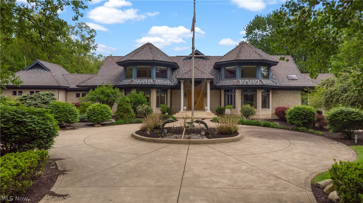 Unique opportunity to own approximately 24 private acres of private estate in the heart of Avon filled with mature trees, scenic greenery, and a tranquil pond. Set behind a private gated entrance, this exceptional property features a main residence, guest house, and versatile spaces suited for various living arrangements.The main home offers over 11,000 square feet of finished living space with 4 bedrooms, 5 full baths, and 2 half baths. Quality craftsmanship is showcased throughout with extensive oak trim, custom carved solid oak doors, marble foyer, tile roof, copper gutters, and stained glass accents.  The spacious kitchen features large windows overlooking the pond, an eat-in breakfast bar, dual sinks, wall ovens, abundant cabinetry, private dining nook and extensive storage space. The spacious primary suite features dual bathrooms, while additional highlights include a four seasons room, deck, and gazebo overlooking the pond and surrounding landscape. Distinctive custom details include a teak carved boat bar, teak office, and teak ceiling accents. Designed with both everyday living and entertaining in mind, the expansive layout includes a formal dining room, living room, multiple gathering spaces, generous closet space throughout, main floor laundry and large family room with stone fireplace. The fully finished lower level adds additional living and entertaining space with a second family room featuring a fireplace and a full kitchenette. The guest house offers over 1,700 square feet with 2 bedrooms, 1 full bath, 1 half bath, bonus rooms, private laundry, and its own amenities, making it well-suited for multigenerational living, extended stays, or additional flexible living space. Car enthusiasts and hobbyists will appreciate the heated oversized attached 3-bay garage plus detached 2-bay outbuilding providing storage for up to 5 vehicles. A rare opportunity combining acreage, privacy, craftsmanship, and flexibility in a sought-after location.