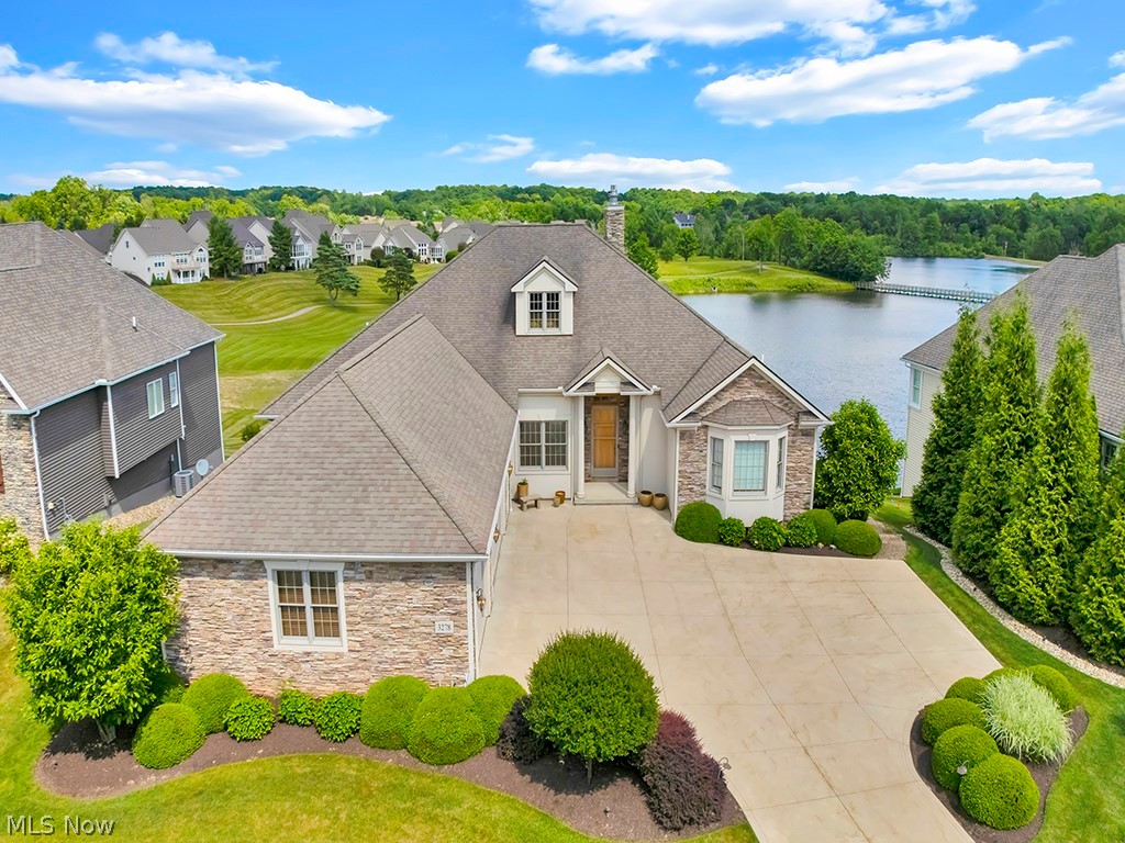 Beautifully positioned on the lakefront, this custom-built ranch offers more than 5,000 square feet of exceptional living space, showcasing an open-concept design with soaring ceilings, expansive windows, and quality finishes throughout.
The main level features a private office, a comfortable great room with a fireplace flanked by custom built-ins, a spacious dining area, a well-appointed kitchen, and a sun-filled four-season room that captures the beauty of the surrounding landscape. The luxurious primary suite serves as a private retreat, complete with a balcony overlooking the lake, a custom boutique-style closet, and a spa-inspired bath with dual vanities and a relaxing jetted soaking tub. Two additional bedroom suites each offer a private en-suite bath.
Designed for both entertaining and everyday living, the finished walkout lower level features expansive gathering spaces, a private guest suite with an attached bath, an additional flex room, and dedicated sauna and massage rooms. Step outside to the elevated deck and enjoy tranquil lake views, where Blue Herons and swans are frequent visitors.
Residents enjoy exceptional community amenities, including a restaurant/brewery, outdoor pool, tennis courts, and pickleball courts, and scenic walking trails, creating a resort-style lifestyle right at home.