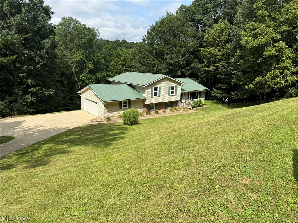 SPACIOUS 3 Bedroom, 2 Bath (plumbed for 3rd Bath), Vinyl Sided split level home with METAL ROOF sits on a VERY PRIVATE SETTING in THE WONDERFUL LAKE BUCKHORN COMMUNITY. VERY PRIVATE LOCATION...No other homes are visible behind (Pond/Rec Area that is Heavily Treed) this home, to the sides or even across the street when the leaves are on the TALL, MATURE TREES  Surrounding this 2.07 ACRE SETTING with a WOODED RAVINE on the most southerly lot for continued Privacy.  This home also OVERLOOKS the Private NorthWest Fishing Pond. Views of the Pond through the filtering of the Tall, Mature Woods to the rear of this home. In addition to this Lovely Home with an ATTACHED 2-CAR SIDE LOAD Garage, there is a 2-STORY OUTBUILDING 28x24 w dedicated 200 AMP electric service (200volt outlet is in). Upper levels is drywalled and has nice laminate flooring. Lower level is 90% finished w plywood walls. HEATED & AIR CONDITIONED. Upper level is well suited for your hobbies or a studio. Lower for Carpentry, tinkering w autos etc. The SERENELY Located rear deck off the dining room overlooks the mature trees on 3 sides and the stocked north west pond down below. The DECK is built with Nearly MAINTENANCE-FREE COMPOSITE DECKING, VINYL POSTS & RAILS & Metal ballisters. ThIS OPEN FLOOR PLAN home features 3 Bedrooms, 2 Baths, Very Nice CUSTOM AMISH-Built CHERRY Finish CABINETRY by MULLET CABINETS, MASTER SUITE w PRIVATE EN-SUITE Bath has shower over the tub, Large FAMILY ROOM, a nice Living Room & Dining Room.  Most of the Living Areas feature Long Lasting, Easy Care LUXURY VINYL FLOORING. Full CEMENT Driveway and Private Rear Deck. This is just a short distance from the desirable NORTH BEACH at the Rec Area 7. The LAKE BUCKHORN COMMUNITY features 1,120 ACRES with the Lake composing 220 of those Acre. The are 2 Beaches, a Social Hall, 5 Pavillons, 2 PlayGrounds, PickleBall Courts, Tennis Courts, Softball Field, Boat Launches, Multiple REC AREAS throughout the Community.  VERY ATTRACTIVE FEES !!!