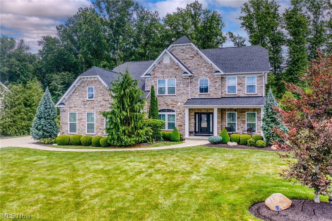 Luxury, comfort, and privacy define this elegantly and extensively upgraded colonial in Palmer Village! Situated on a double lot bestowing timbered tranquility, an all-stone front masterpiece offers 4 BR, 4.5 BA, and 4,953 sqft of high-end living. The front porch opens to a 2-story foyer where engineered wood floors extend forth. Glass-paned french doors open to an office w upgraded crown molding. Designed for refined entertaining, the flex/living room and formal dining room are encased by extensive trimwork. At the heart of the home are oversized open-concept spaces for comfortable everyday living. The generously-sized great room with a 4' extension provides space for the entire family, ornamented by a custom fireplace encased by split-face ledger stone. The supremely appointed chef’s kitchen offers pullouts, granite countertops, extended center island w breakfast bar, a double oven, a butler's pantry w minifridge, XL walk-in pantry, and spacious morning room (4' extension) including an expansive built-in buffet adding extra counter space and storage. This floor finishes with a powder room and a closeted mudroom. Upstairs, the imperial owner’s suite boasts a massive bedroom w tray ceiling, a sitting area, dual oversized WICS, dual sinks/vanities, a tranquil soaking tub, tiled walk-in dual-headed shower, WC. There are also three guest bedrooms (one w ensuite bathroom), a dual-sink hall bathroom, and deluxe laundry room w cabs and convenient folding station. The professionally finished garden basement (egress) includes a versatile rec room, full bath, a room w hidden closet, and storage space w shelving and a rubber mat floors for a home gym. Enjoy exceptional outdoor living--choose sun or shade on the ~708 sqft stamped patio or 17'x10' covered deck w blinds for privacy/sun protection. The sprawling lawn framed by evergreens and a canopy of scenic woodlands provides natural beauty and an enviable solitude. Come home to true luxury.  INQUIRE FOR FULL LIST OF UPGRADES.