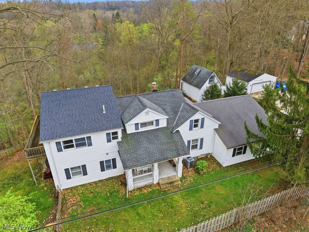 You're going to be excited about this 2 for 1 set-up only a 7 minute drive to downtown Chagrin Falls. The house has a 1st floor bedroom with ensuite, 1st floor laundry, pantry, 2nd full bathroom, formal living, dining & family room. There are treetop views through sliding rear doors off the family room, and the fenced yard is whatever you need it to be — a dog run, a garden, or a Tuesday evening with a drink and nowhere to be. Upstairs, the bedrooms are genuinely oversized (not "fits a queen if you angle it" oversized — actually oversized). 4 beds up share a 3rd full bathroom. The main house has a new HVAC ('25), well pump replaced ('25) and a freshly pumped septic in '25 — updates that aren't glamorous but ABSOLUTELY matter. And a 3 car ATTACHED garage? Yes, please! The house sits closer to the road than you might expect so know that going in, but once you're on the property, the setting does its job: it's peaceful, and surprisingly removed from everything while being close to everywhere you want to be. Then there's the all electric bonus cottage. It has its own kitchen, laundry, full bath and loft and its OWN two-car garage. The cottage is the kind of bonus space that makes you rethink what a property can do.  A private retreat for a parent or independent adult child, a studio or office you can actually leave behind at the end of the day, a guest space that gives everyone their own front door — the math works a lot of different ways here. This property has options most properties won't give you. West Geauga Schools. Seven minutes to the CF Village. One acre. Someone's going to figure out how good this is — it might as well be you. Selling as-is.