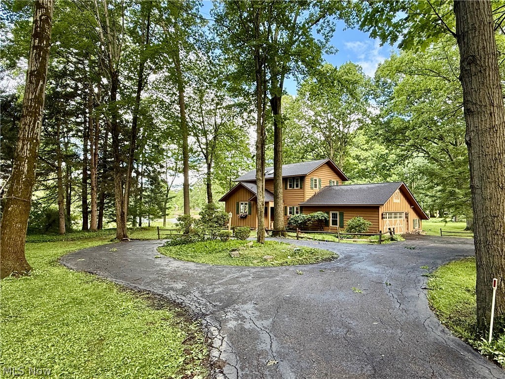 Rare opportunity to own 1.23 acres of private lakefront property in the highly sought-after Pilgrim Village community of Chagrin Falls. Surrounded by mature trees and offering breathtaking water views, this distinctive home combines privacy, natural beauty, and an exceptional recreational lifestyle. Residents enjoy exclusive access to community amenities including a private beach, pavilion, playground, sand volleyball court, diving boards, docks, and lake access.

Inside, the spacious floor plan is filled with character, featuring warm wood accents, exposed beams, oversized windows, and stunning lake views throughout. The expansive kitchen offers abundant cabinetry, generous workspace, and a large center island that opens to adjoining living and dining areas, creating an ideal setting for entertaining. A beautiful fireplace anchors the main living space, adding warmth and charm.

Designed to maximize its incredible setting, the home offers multiple spaces to enjoy the outdoors. The three-season room overlooks the lake and provides the perfect spot to relax and take in the scenery year-round. Step outside to the large deck overlooking the shoreline, ideal for outdoor dining, entertaining, or simply enjoying peaceful waterfront views. The spacious primary suite features a private second-story deck with panoramic lake views, creating a true retreat.

Major updates include a new roof, furnace, and central air conditioning in 2024, providing added value and peace of mind. With three bedrooms, two full baths, a half bath, an attached two-car garage, and one of the most desirable settings in Pilgrim Village, this property offers a rare opportunity to enjoy lakefront living in a highly sought-after community.