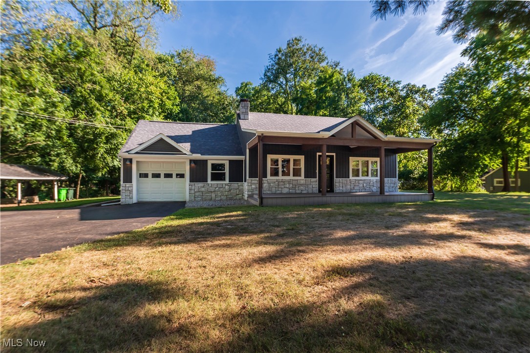 Welcome to 1050 Easthill St SE. Set on 1.36 acres of wooded privacy, this fully remodeled bungalow-style home blends charm, comfort, and modern finishes in one beautiful package. Originally built in 1950 and completely updated in 2021, every detail has been thoughtfully done so you can move right in and enjoy it. The inviting front porch spanning the width of the home sets the tone, perfect for morning coffee or evening relaxation during the sunset. Step inside to a bright living room with stunning wood-accented ceiling cathedral ceilings, and a cozy fireplace.
The heart of the home is the gorgeous kitchen, featuring granite countertops, custom cabinetry, stainless steel appliances, and a spacious island with seating. Sliding glass doors open to the backyard, making it easy to enjoy the peaceful wooded surroundings. This home offers 2 bedrooms and 3 full bathrooms, with a third bedroom in the finished basement. The lower level also adds 384 sqft of living space, perfect for a guest suite, rec room, or media area. Each bathroom has been beautifully remodeled with modern vanities, custom tile work, and updated fixtures, giving the home a fresh, luxurious feel.
With its blend of modern updates, private wooded lot, and unbeatable location near shopping, dining, and excellent schools, this property offers both privacy and convenience—an ideal place to call home. Come see for yourself how peaceful and move-in ready this home is—call today and make 1050 Easthill St SE your new retreat in North Canton.