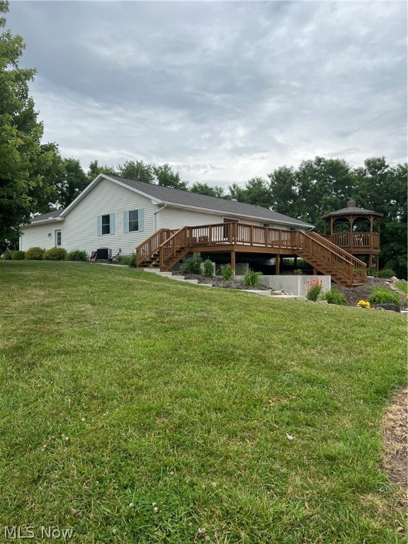 Check out this Beautiful Country Ranch home with a Hilltop Setting and views of Holmes County rolling hills on 5.5 Acres. This home is currently operating as a Vacation Home and is turn-key.  Located just minutes from Mohican Country and Amish Country.  Enjoy nature and relax on the expansive back deck with attached gazebo, custom patio with firepit or the cozy front patio area.  As you enter the home you are greeted with an open concept and mid-century modern de cor.  The updated kitchen is bright and invites you in for the gatherings.  In the living room is a brand new custom fireplace and seating along with a sliding glass door that leads from the living room to the large back yard deck.  Down one short hallway you will find a guest bathroom and 2 bedrooms with a fun mural, hand-painted by a local artist. Down a separate hall is the primary bedroom that boast of color and character, a complete on-suite bathroom. Large and spacious first floor laundry and mud room is off the 2 car at